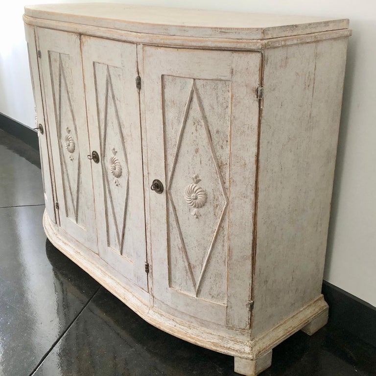 Large 18th century Swedish period Gustavian sideboard in classic Gustavian manor; rounded form with four paneled doors with diamond shaped lozenges, resting on block feet. Wonderful find with skillfully carved details!
Göteborg, Sweden circa 1790.