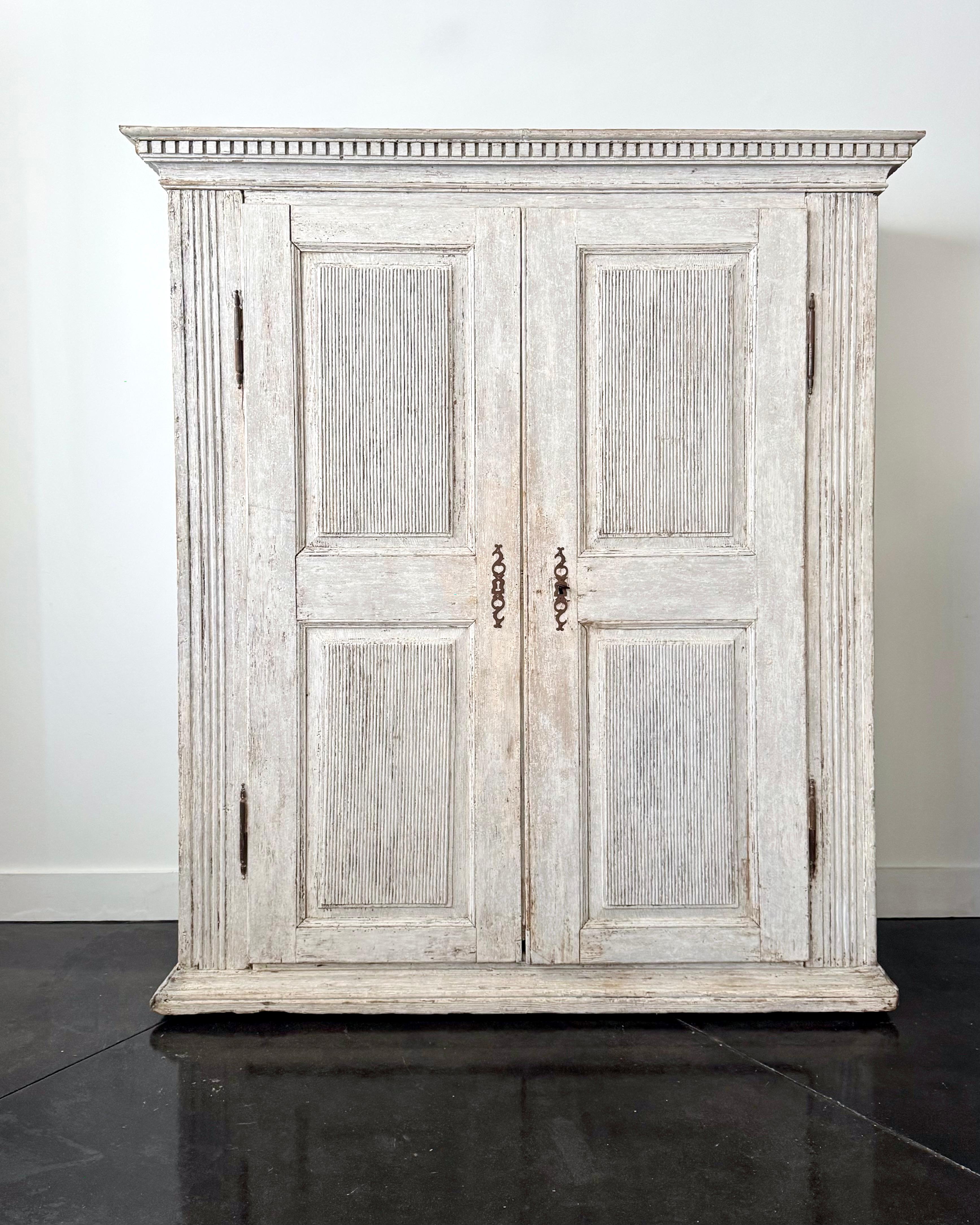 Very Classic styling of Gustavian period tall cabinet or armoire with reeded door panels, reeded side posts and reeded paneled side panels in palest of gray. Very practical with plenty of storage.
Sweden, circa 1780.
More than ever, we selected the