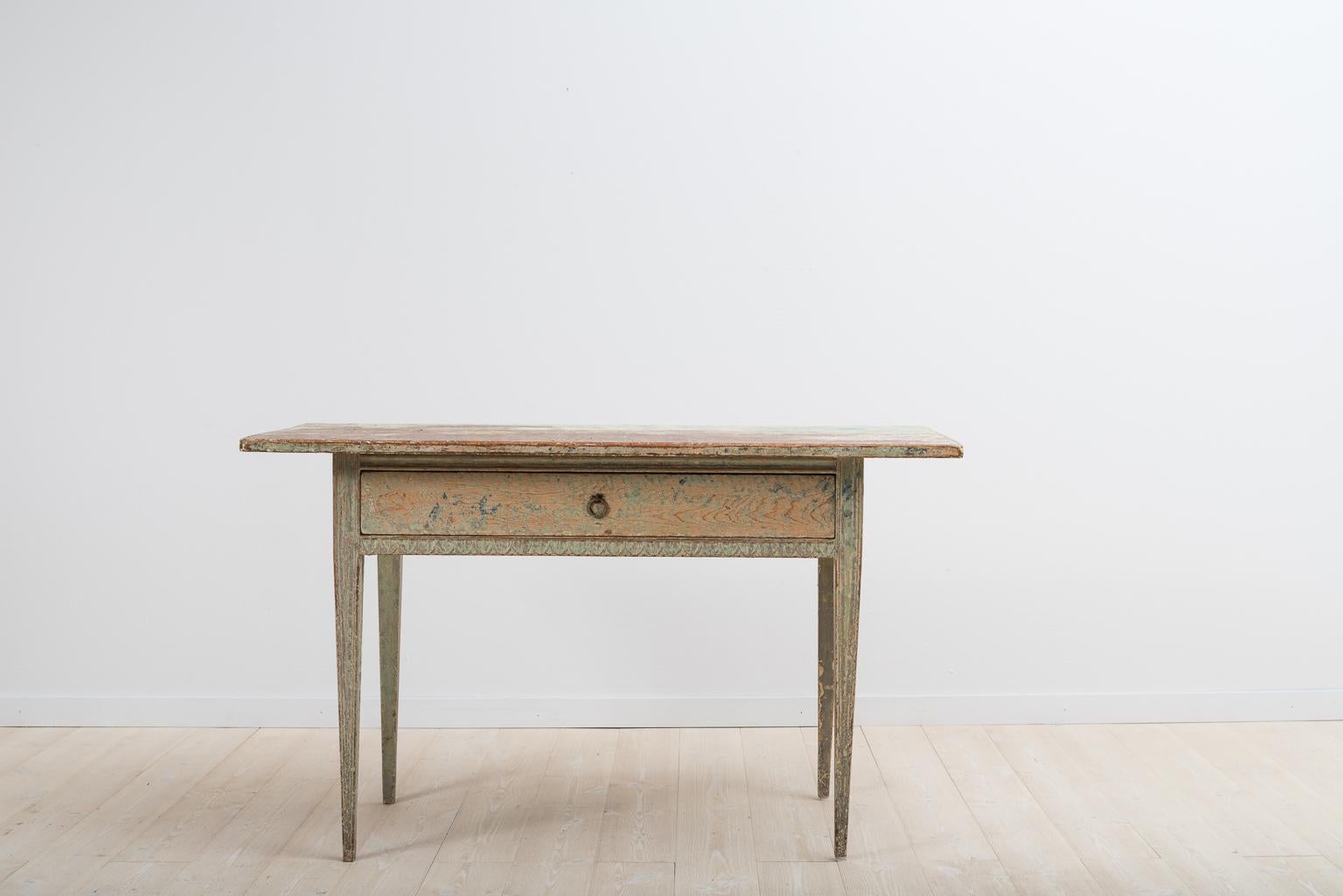 Swedish Gustavian table scraped to original paint with straight tapered legs and rims with carved wooden decor. The table gives off a rustic feel as the surface has been dry scraped to its original late 18th century paint. Healthy and solid frame.