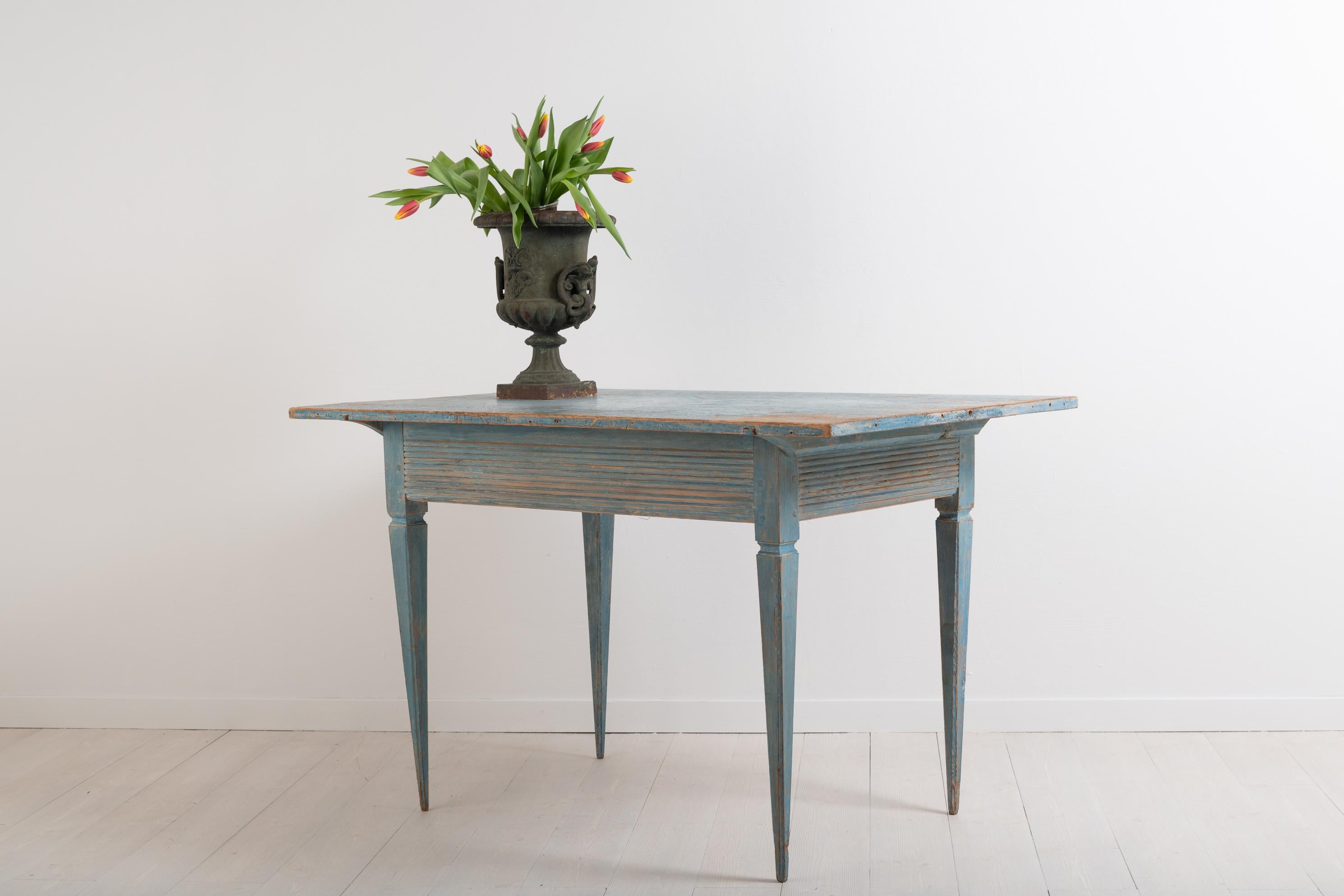 Gustavian side table from northern Sweden. The table has a ribbed rim and straight tapered legs. Original blue paint with natural patina and distress. The side table is equilateral, all sides are of equal length. Made circa 1790 in healthy and solid