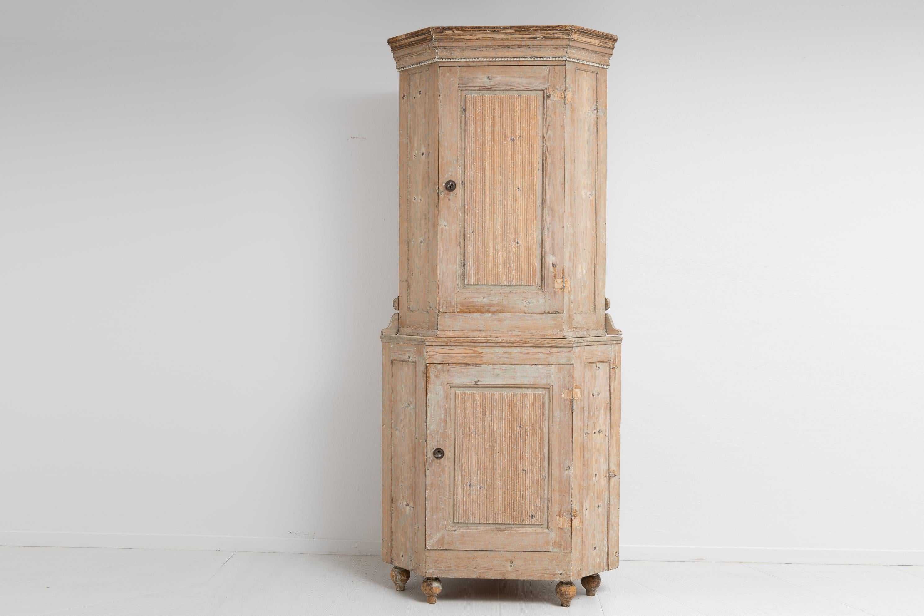 Northern Swedish gustavian corner cabinet from the late 1700s, 1790 to 1800. The cabinet is pine with traces of the original paint. Typical gustavian angles and features such as the doors with ribbed decor. Interior shelves. The cabinet has a loose