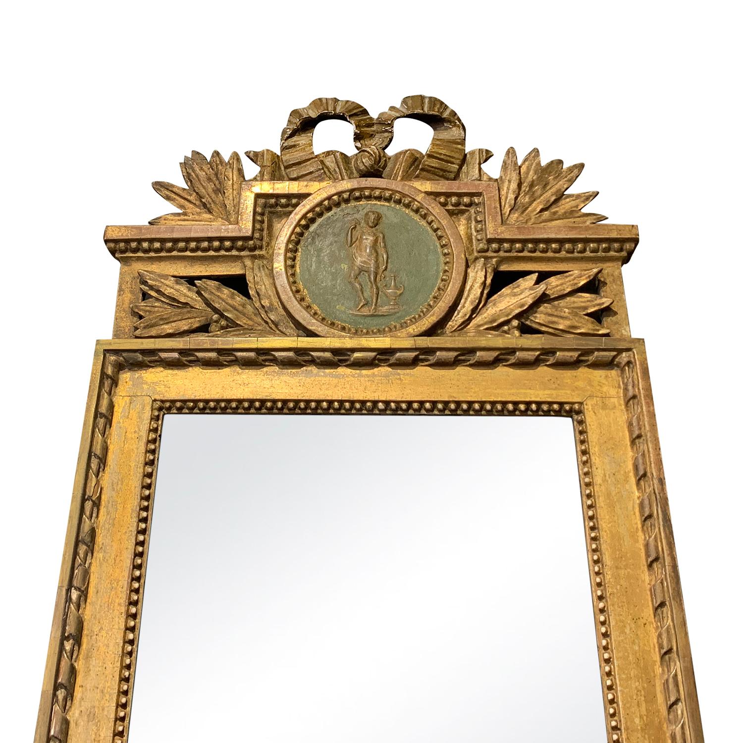 An 18th Century Swedish Gustavian mirror gilded with original glass. Richly hand carved antique wall mirror in the Gustavian style with medallion in good condition, enhanced by detailed wood carvings. Minor fading, scratches due to age. Wear