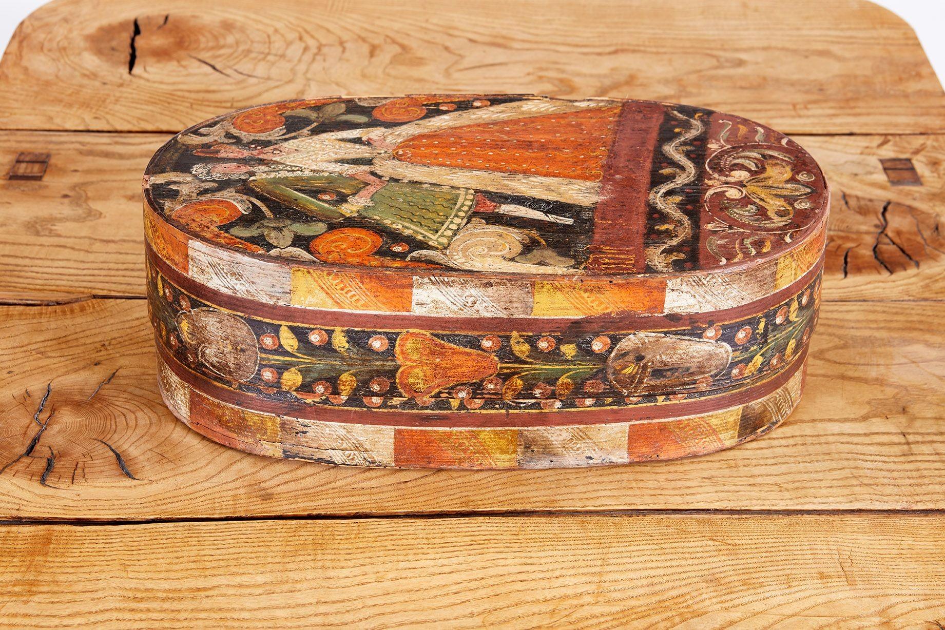 Very fine 18th century Swedish painted oval pantry box made to celebrate a wedding, depicting a loving couple in their period finery, surrounded by border of fruits and flowers, the underside with branded owner's initials 