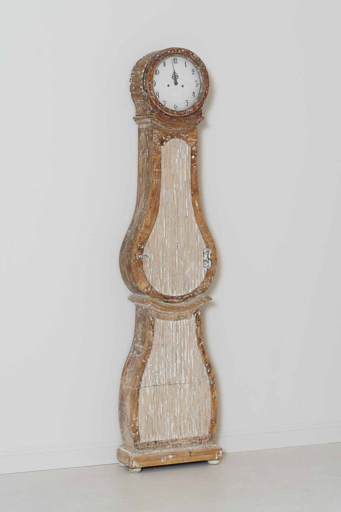 A Swedish Mora clock from the 18th century, circa 1790. This charming clock has been hand-scraped down to the original paint and natural, aged wood. Fully reeded front.
  