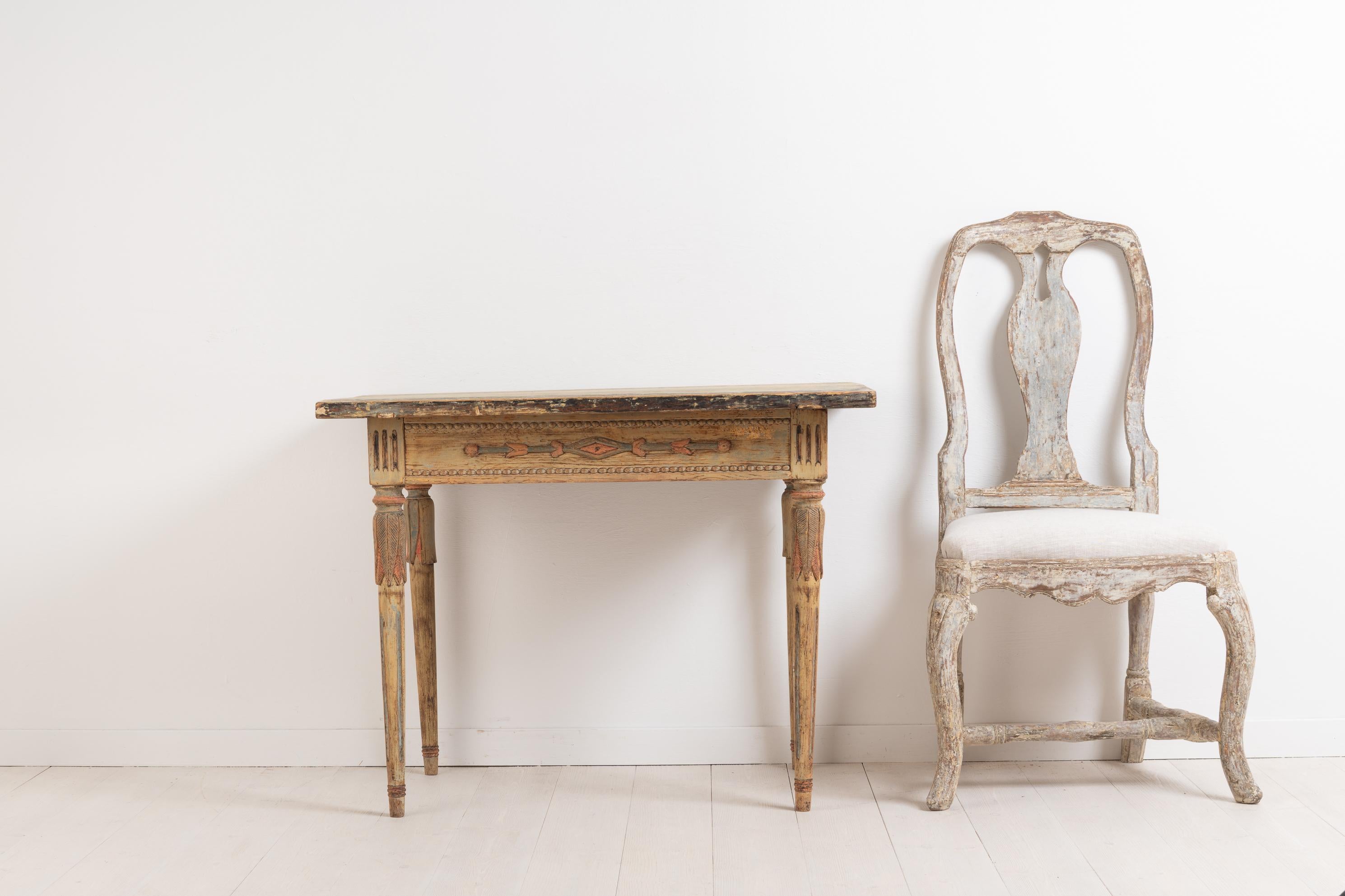 Swedish Provincial console table. The table has been scraped to the distressed original paint. It has a decorated rim in the shape of stylised flowers and Dual strands of pearls. The top of the legs are crafted to look as if they are growing out of