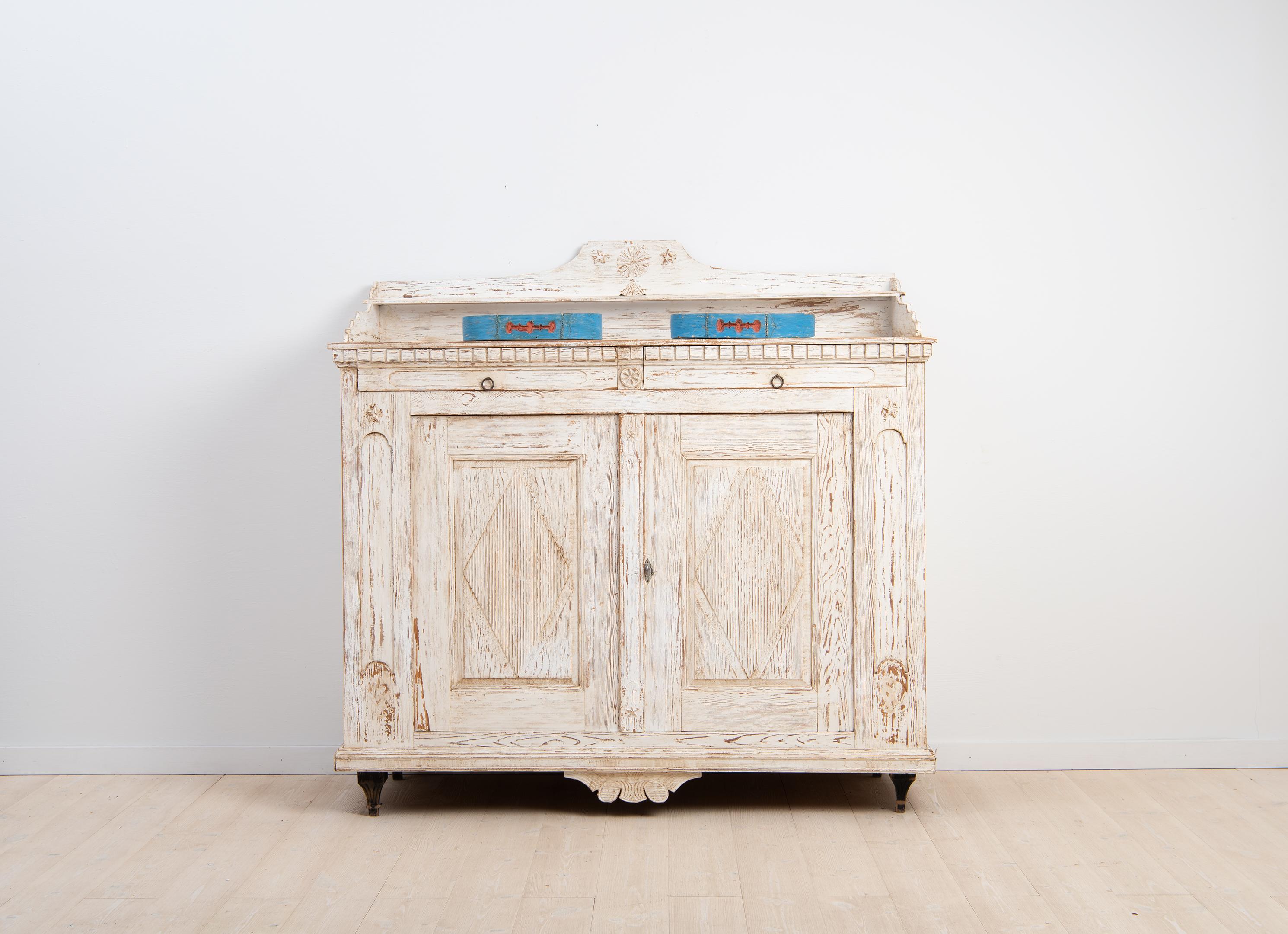 Neoclassical sideboard from Sidensjö in the Swedish province Ångermanland. The sideboard was made during the late 1700s and the material is Swedish pine. The paint is old and historic from the early 1900s and distressed with age. The lock and key
