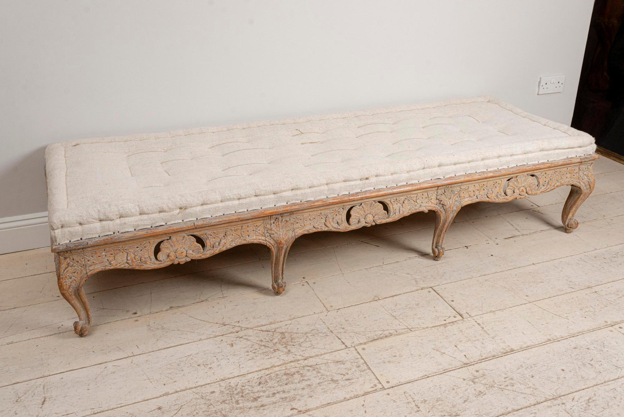 A wonderful bench, coffee table or stool which has carved scrolled decoration to the front and sides which was possibly converted from a sofa at some point in the past. It could also work well as a coffee table or as an interesting statement piece