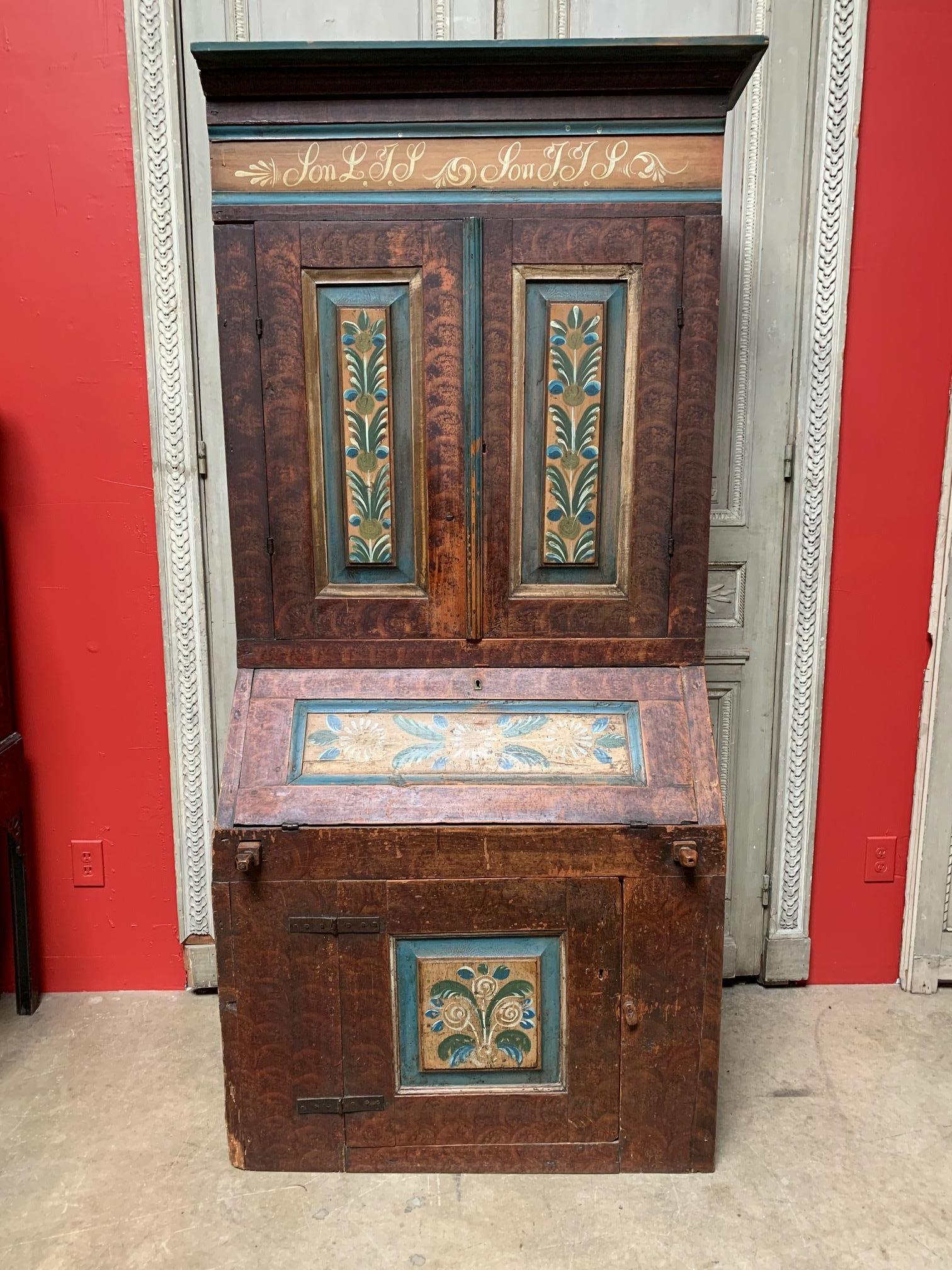 An 18th century Swedish painted secretary, all original.
This understated elegant piece has a beautiful wood patina with lovely hand painted details. Upper cabinet holds copious amounts of keepsakes and/or books, while the slant front lower section