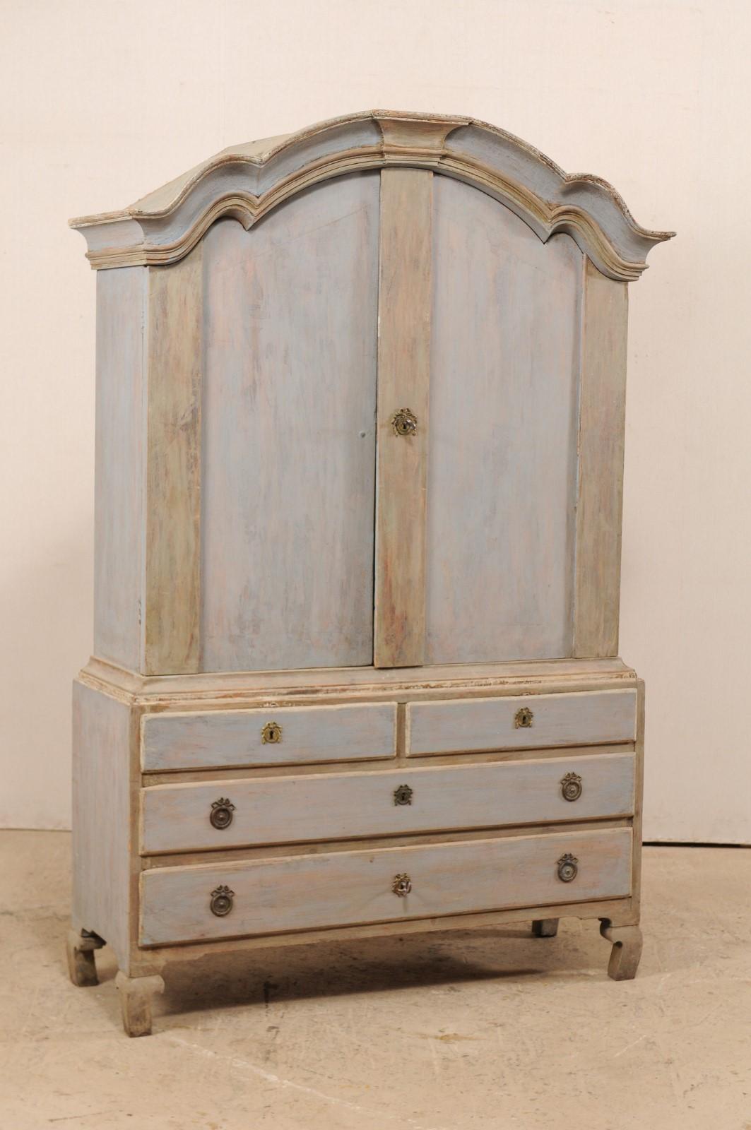 A fabulous 18th century Swedish period Rococo painted wood cabinet with plentiful storage. This antique cabinet from Sweden houses an upper cabinet of two doors, which open on a space divided by two shelves, atop a lower case fitted with a pair of
