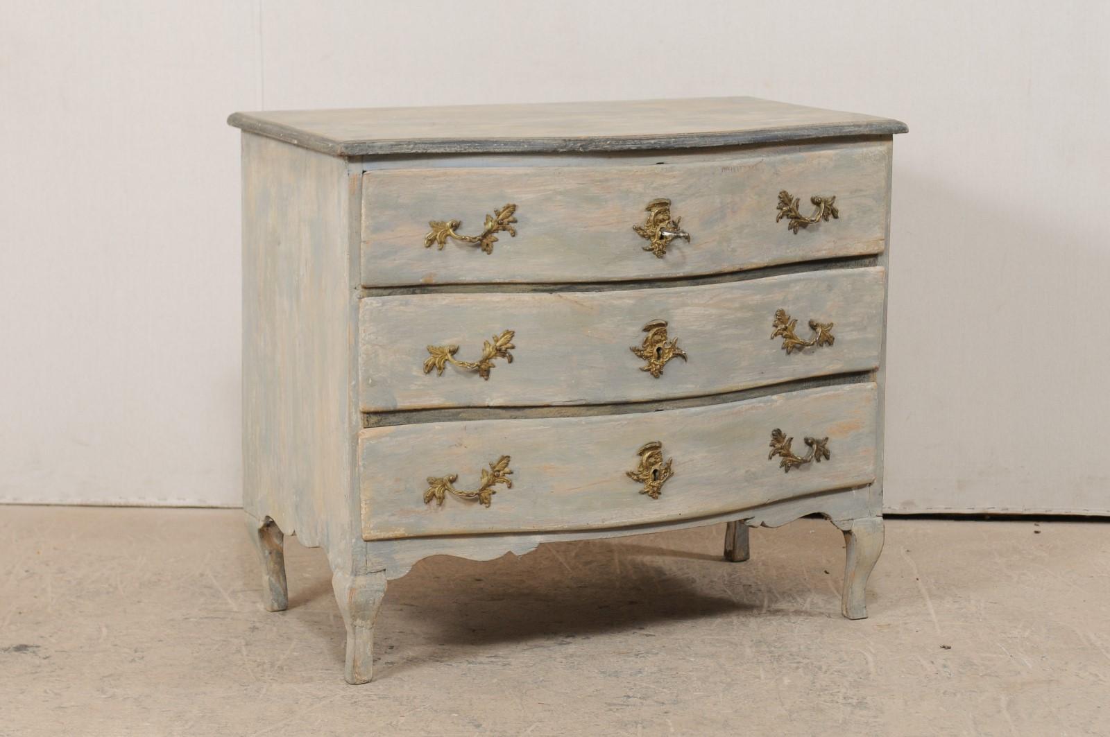 An 18th century Swedish period Rococo chest of three drawers. This antique Rococo chest from Sweden features a delicate serpentine body, accolade carved side skirts, nicely carved trim at either side of front skirt, and is presented upon petite