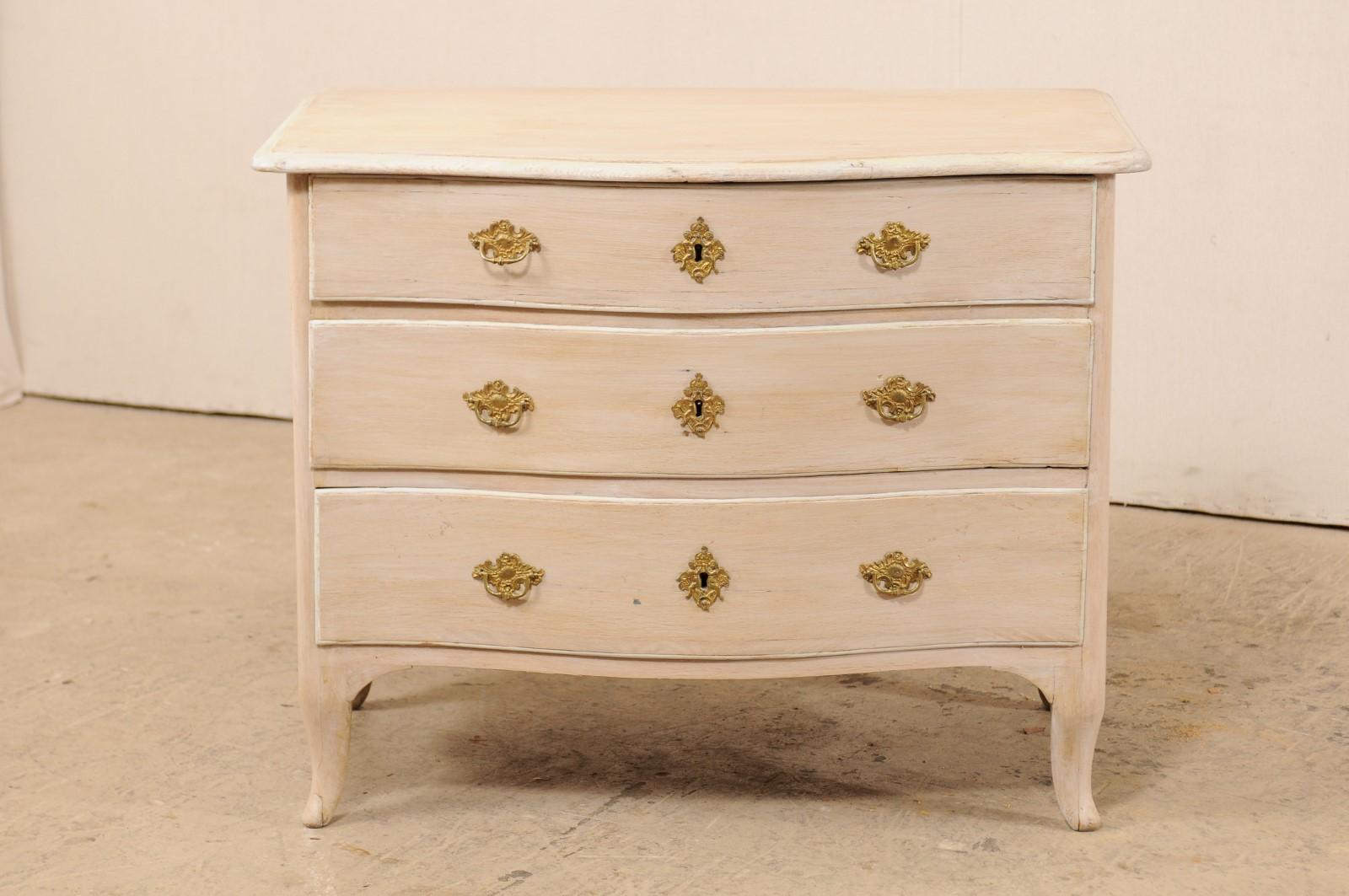 An 18th century Swedish period Rococo painted wood chest of three drawers. This antique Rococo chest from Sweden features a subtly-shaped serpentine body, a slightly overhung top which reflects the shape beneath, swag-carved side skirts with
