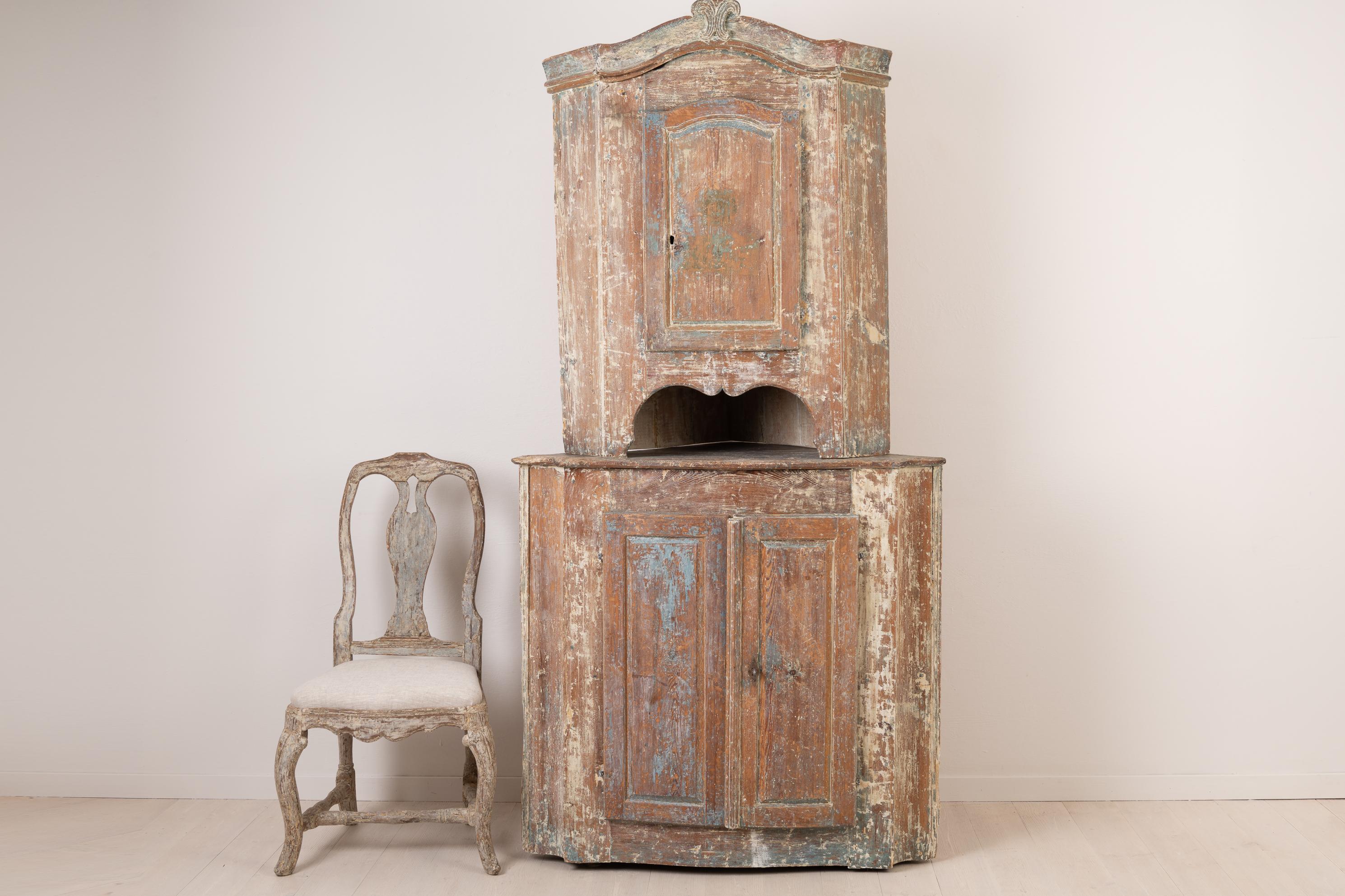 Northern Swedish rococo corner cabinet in painted pine. The cabinet is made circa 1770 in two parts, an upper and lower cabinet. As a natural product of 250 years of use the cabinet has a rustic patina and some traces of the original blue paint.