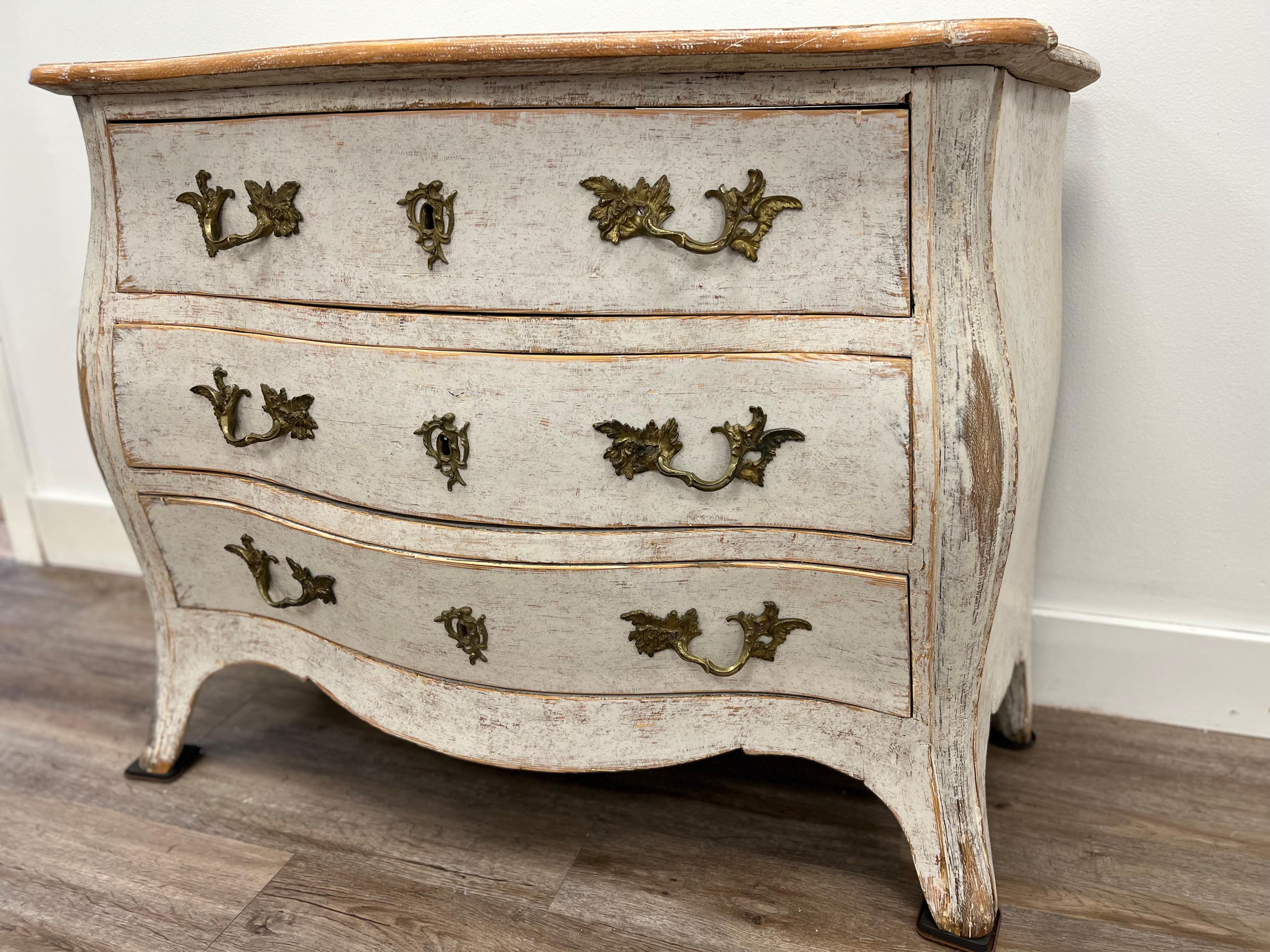 A Swedish Rococo commode with original brass pulls and keyhole covers and later locks. Later soft white paint.