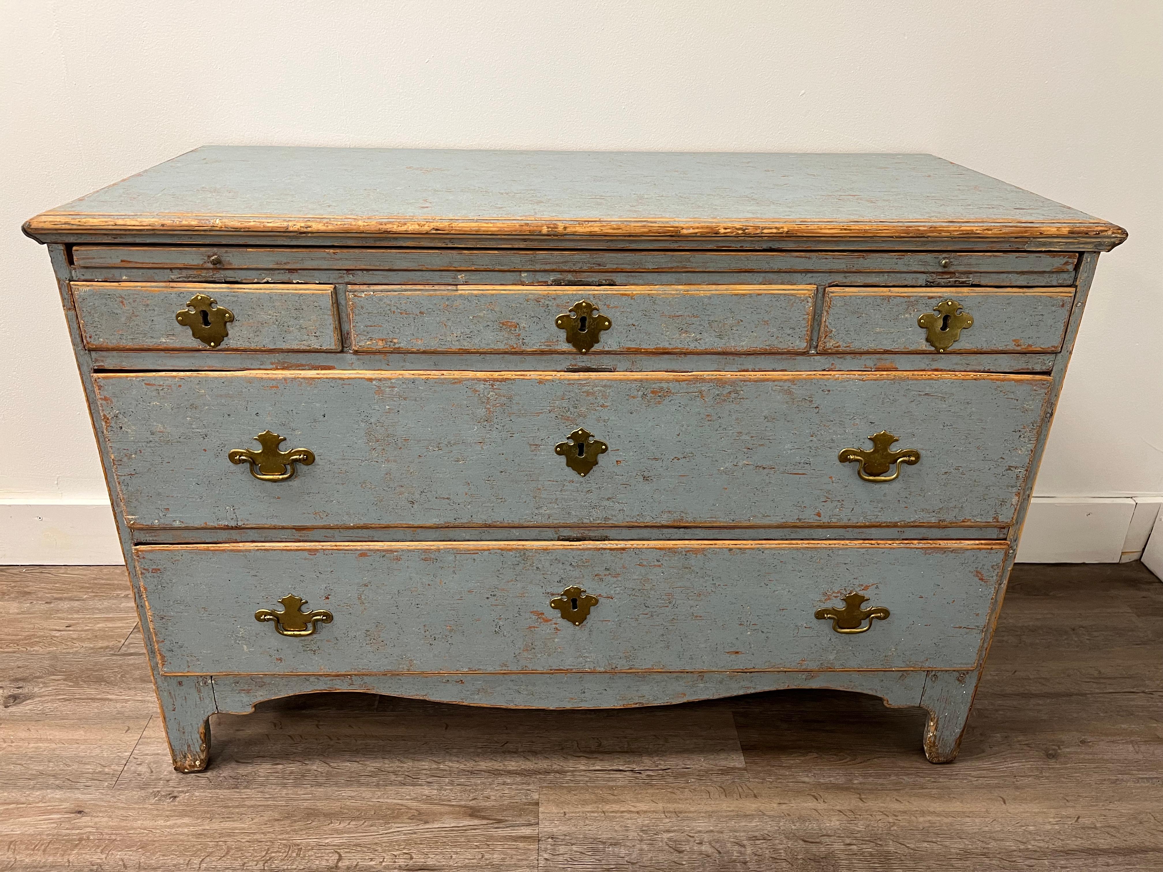 An unusual Rococo commode with original brass hardware. One original lock and four early 20th century replacements. Slide-out shelf over five drawers. Original iron handles on each side. Tastefully repainted in pale blue. 