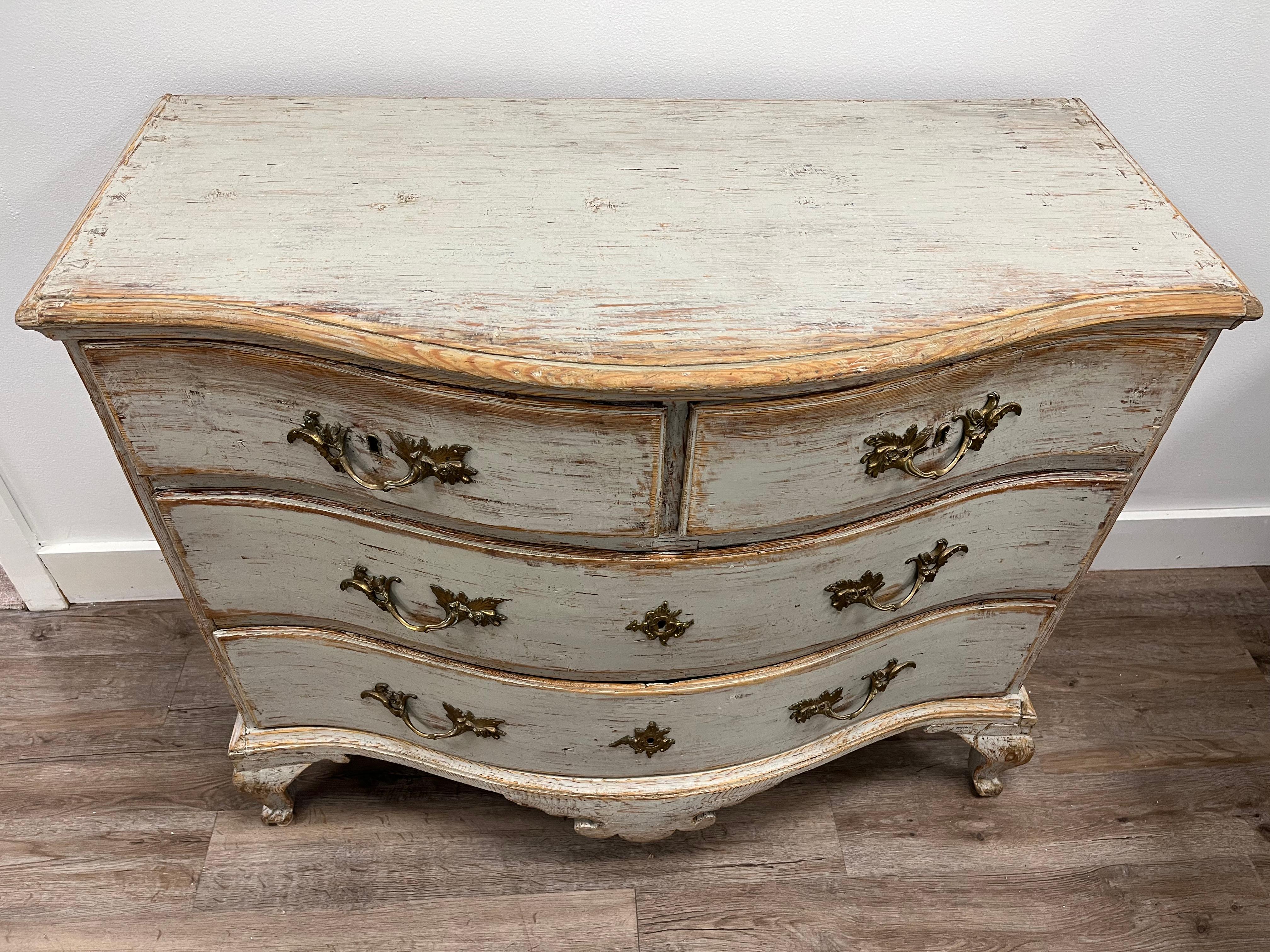 A Swedish Rococo bow front commode with two small drawers on top and two large drawers below. Base has decorative scroll design and cabriolet legs. Original ornate brass hardware, four iron locks and one early 19th century replacement lock.