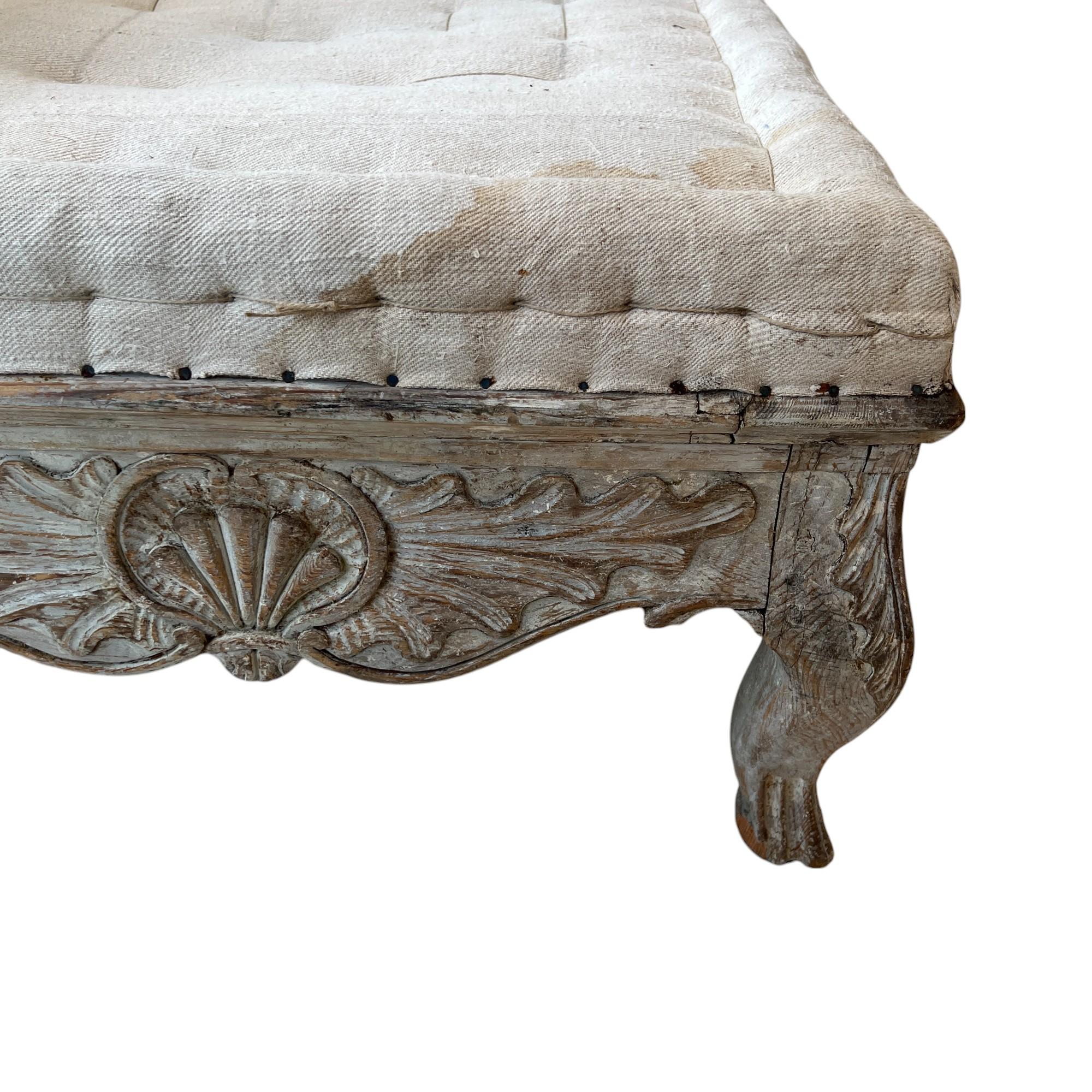 This 18th-century Swedish Rococo long bench is a refined example of the elegant design characteristic of the Rococo period in Sweden. Crafted from carved wood, it features gracefully scalloped aprons, cabriole legs, and delicate scrollwork that lend