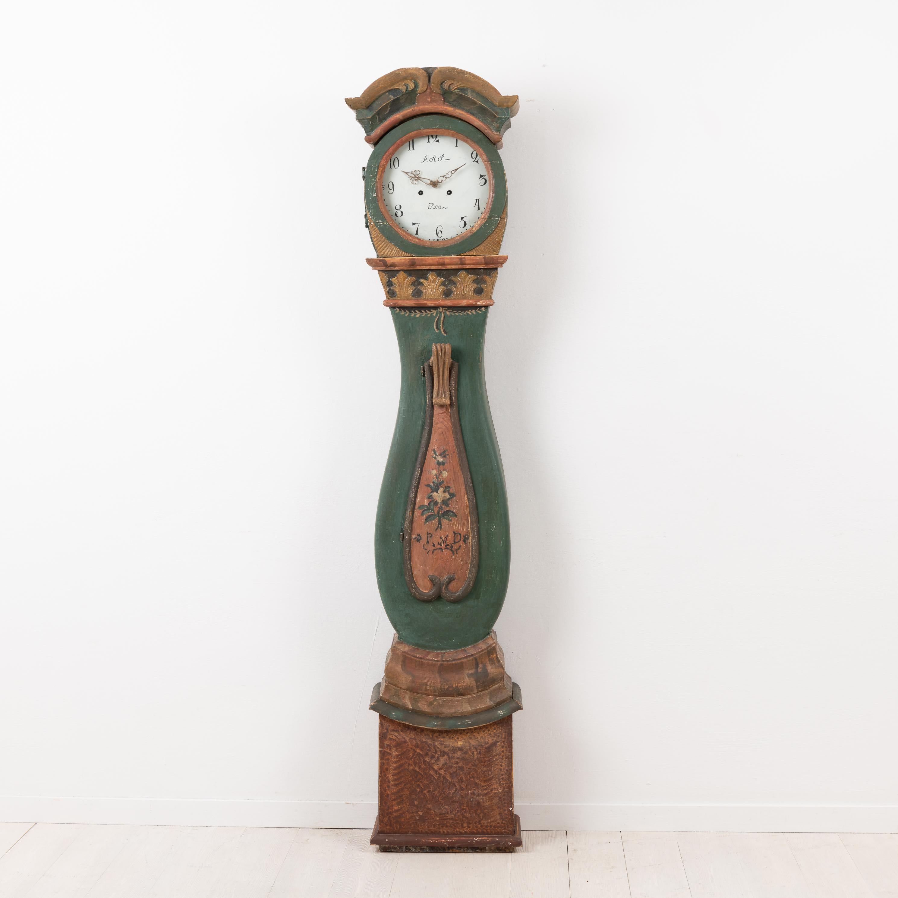 Swedish Rococo long case clock in Folk Art from the northern part of the country. Made in the province Jämtland around 1780 to 1790. The clock is made from large pieces of Swedish pine. Hand carved wooden decorations especially around the top. Old