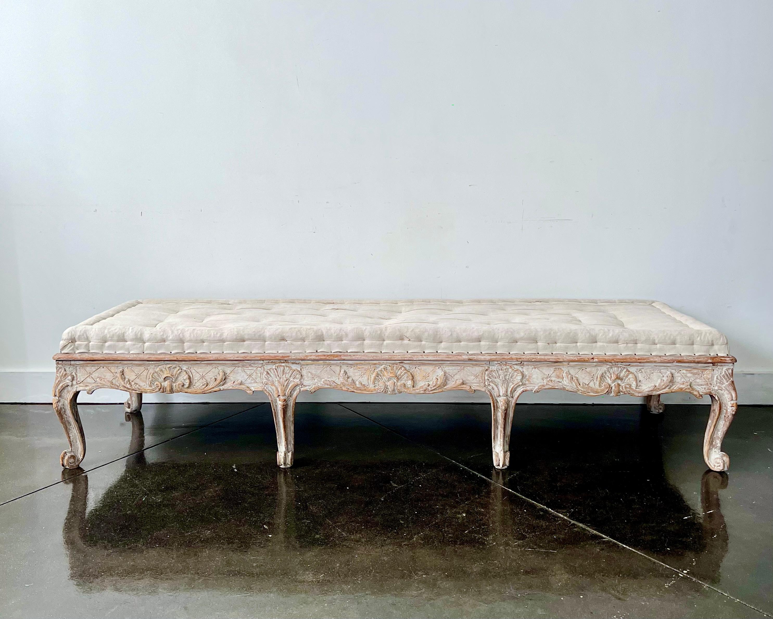 An exquisite, large and rare 18th century period Rococo sofa bench with hand-carved and richly decorated in scrolling carvings to three sides,
Scraped to original cream white finish and upholstered in traditional way in antique hand stitched linen.