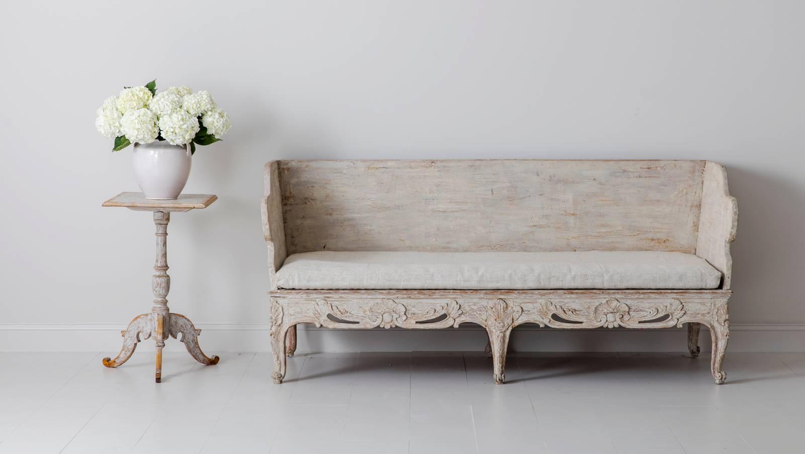 An 18th century Swedish (Tråg sofa) from the Rococo period with original linen seat, back, and side cushions. This is an exceptional and rare period piece that was purchased from a private collection in Belgium. It has been hand-scraped back to