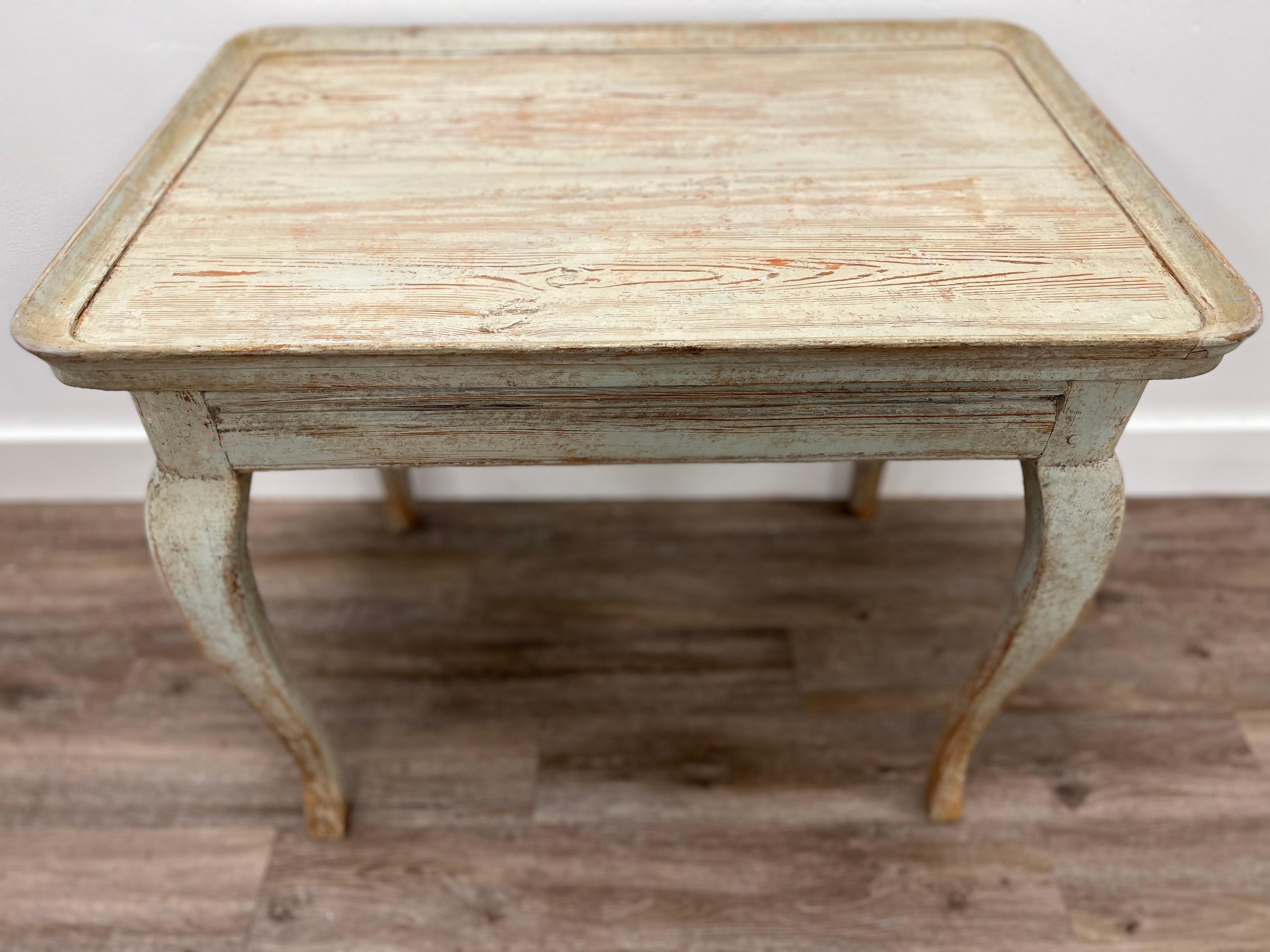 A provincial Swedish Rococo tray table in original pale green-blue paint. Simple inlay detail on base atop cabriolet legs.