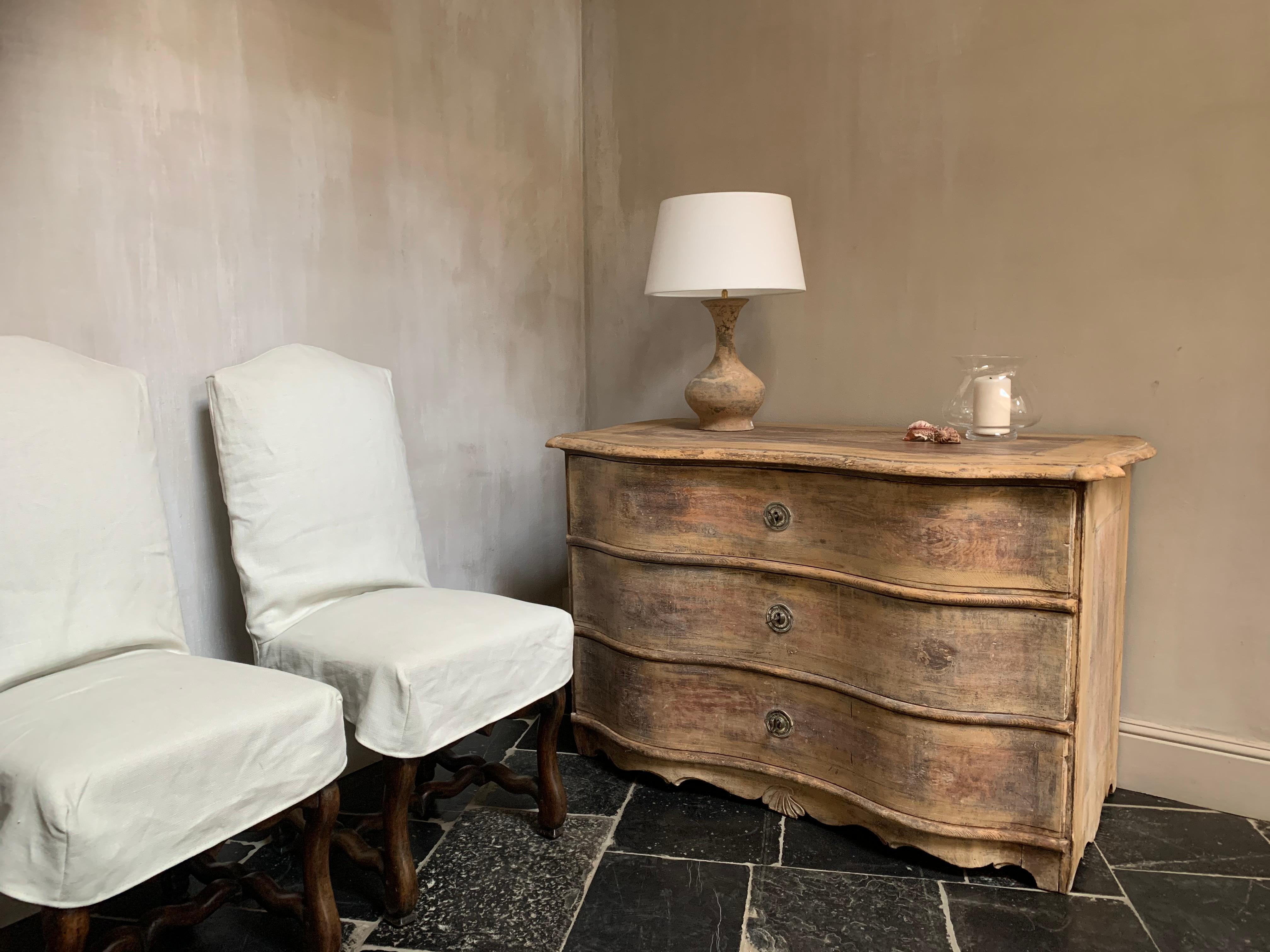 A 18th century Swedish serpentine chest of drawers with the faded original ocre, red and yellow paint.