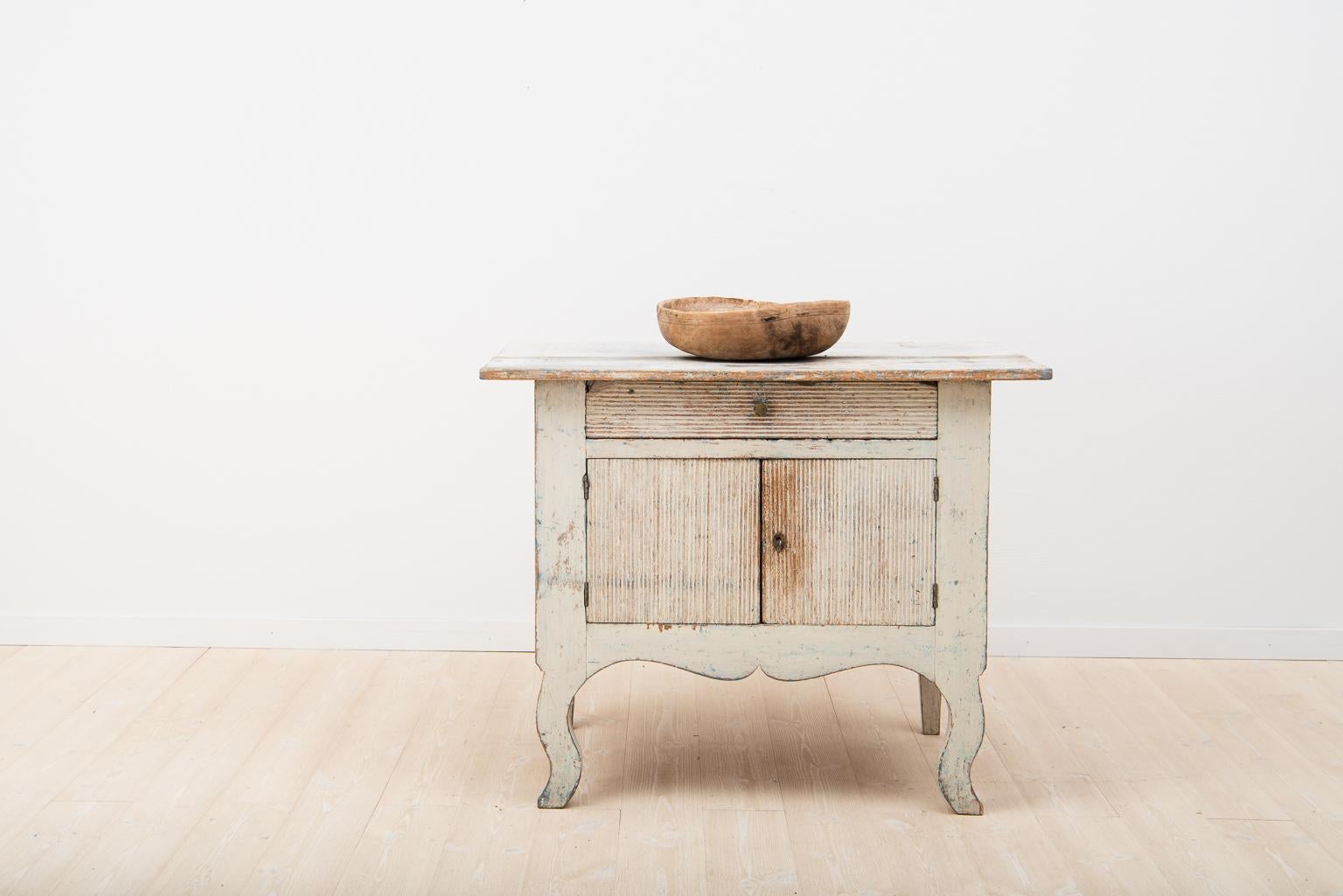 Unusually small Swedish sideboard from the transition period between the Rococo and Gustavian styles. Dry scraped to the light 18th century original paint. Minor loss of material around the drawer’s corners and edges. Tabletop with some wear, Järvsö