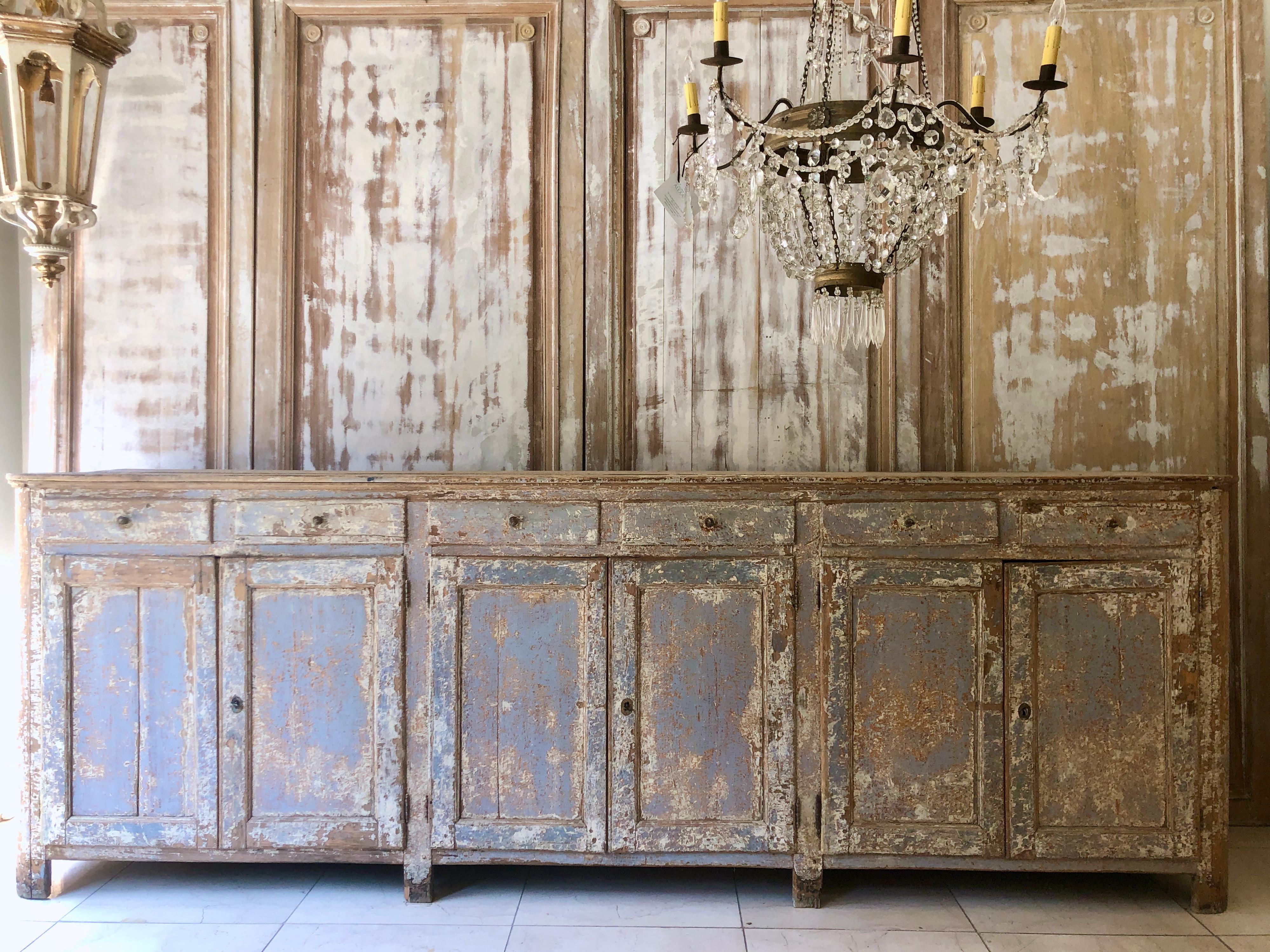 A long 18th century Swedish sideboard with six paneled doors and drawers in remnants of original with and blue paint.
    
