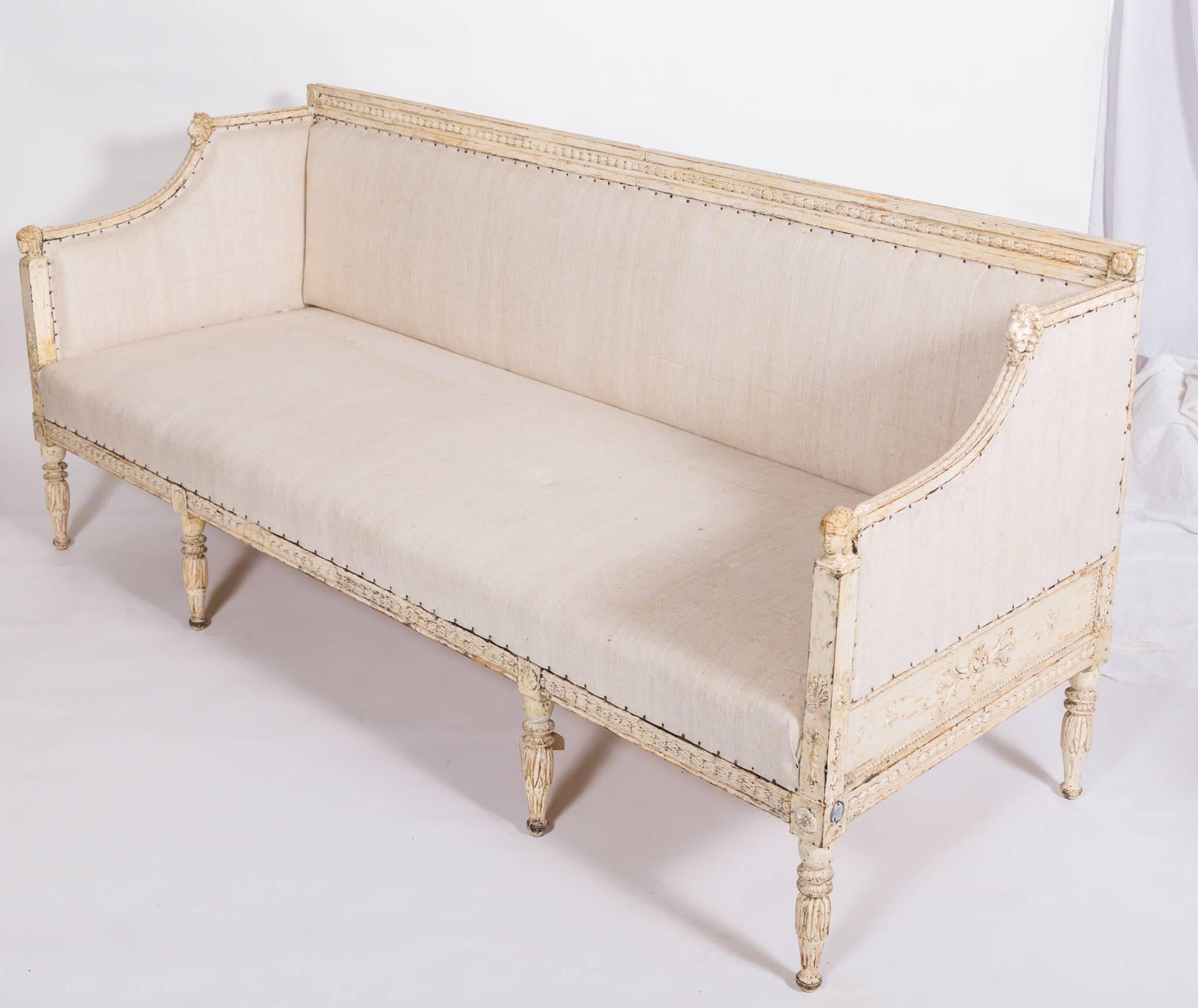 Rare Swedish sofa with detailed carvings that highlight Egyptian influence and neoclassical lion carving. The fluted legs have rosette detail. Bench is covered in a cotton and Belgian linen fabric. Bolsters are not included.