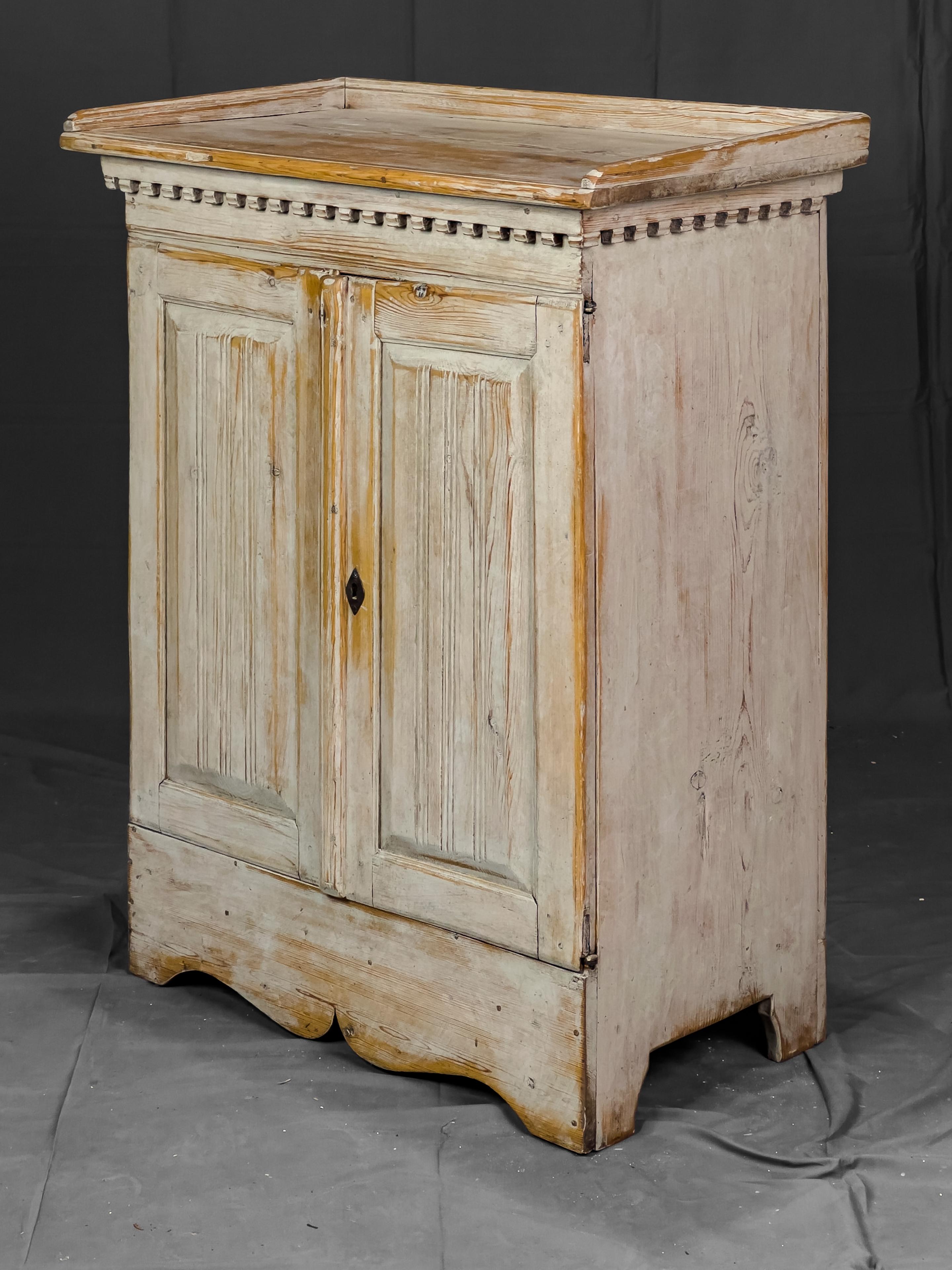 18th Century Swedish two door cupboard with original paint. 

The doors have a reeded and raised panel detail and concealed hinges. 

The top surface has a low backsplash trim and dental molding underneath.

This is a stunning piece and works