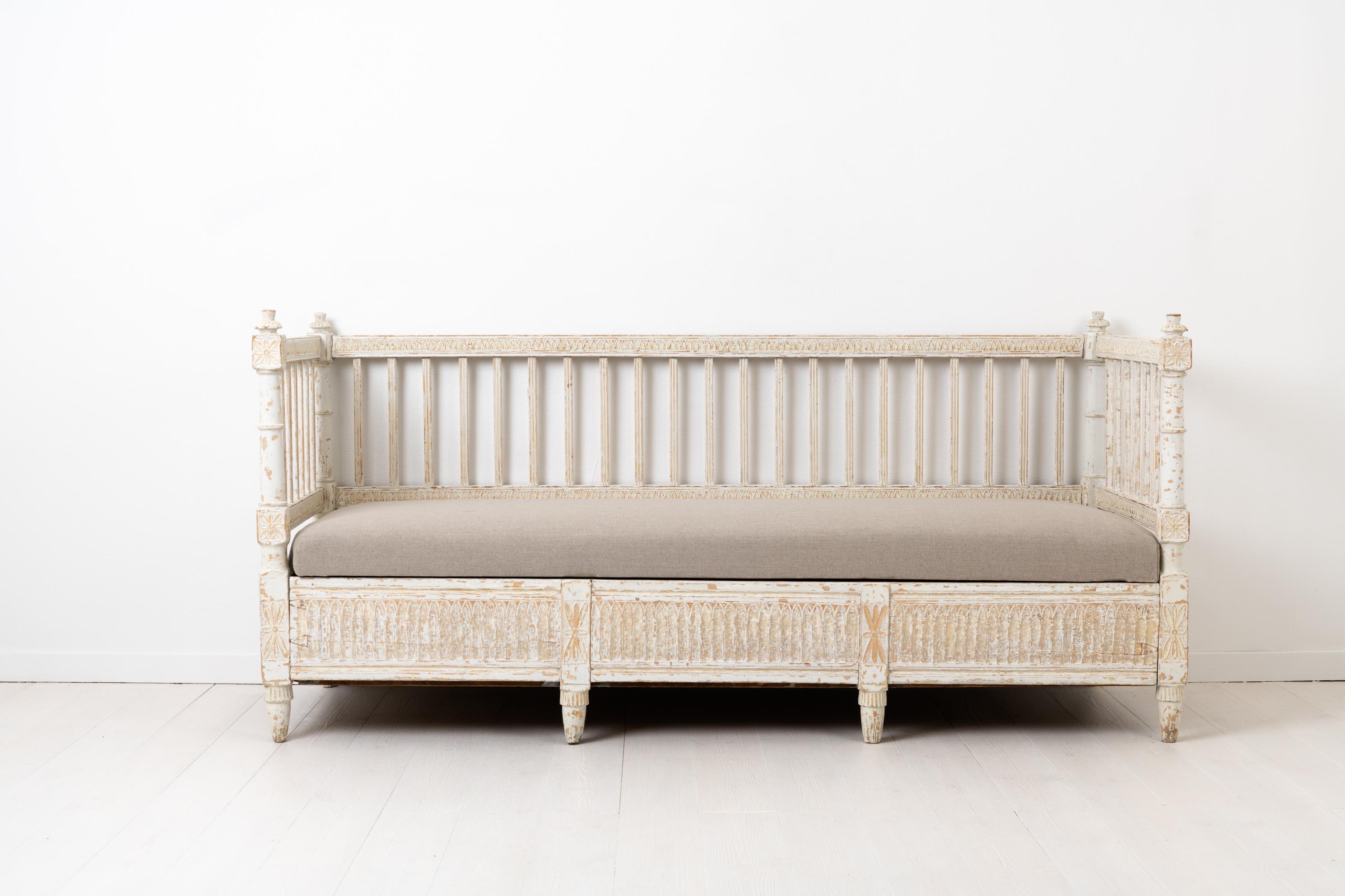 Swedish white 18th century Gustavian sofa made circa 1790-1800. The sofa is pine and richly decorated with wooden decorations carved by hand in the typical Gustavian / neoclassical style. The white paint is old paint from the late 1800s which has