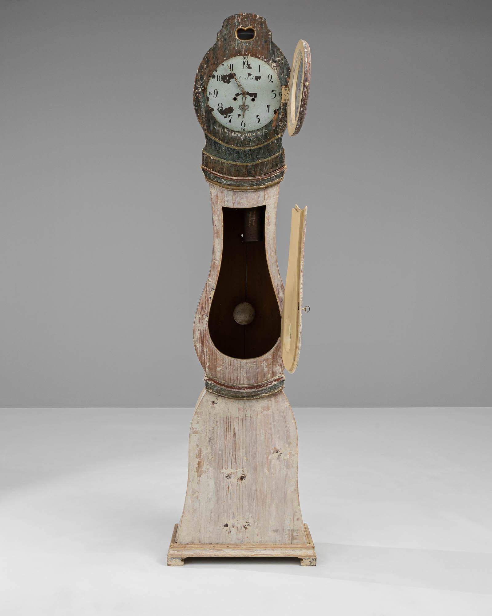 Entrez dans le monde de l'antiquité avec cette horloge suédoise en bois du XVIIIe siècle, qui incarne la grâce et le savoir-faire d'une époque révolue. Son cadre imposant, fabriqué en bois vieilli, porte les teintes douces et délavées que le temps a