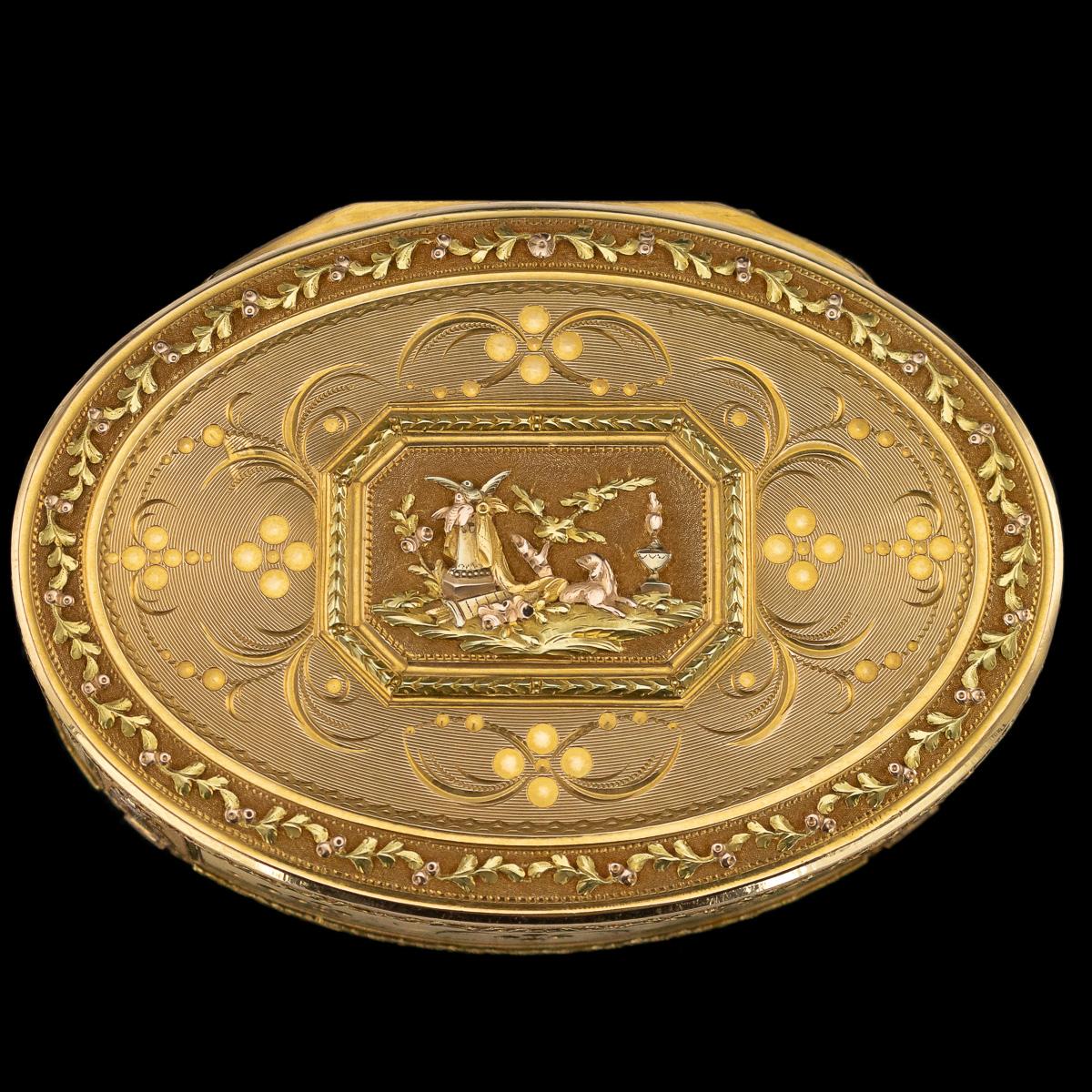 Antique late 18th century Swiss magnificent three-colored 18-karat gold snuff box, of oval form, the lid chased in colored golds with a scene of a dog running away from birds over a basket of flowers, decorated with fine floral scrollwork and