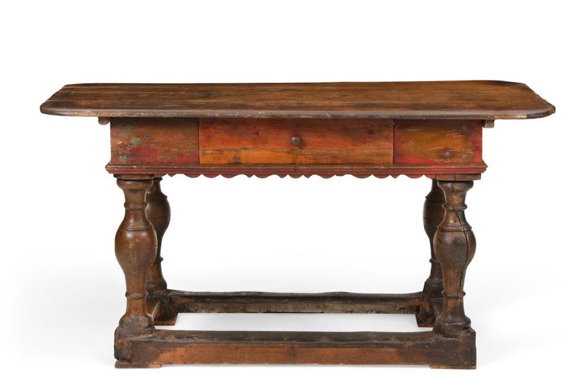 Swiss Baroque parcel red painted pine center table
early 18th century 

Dimensions

height 34in (86.5cm); width 64 3/4in (165cm); depth 30 1/2in (77.5cm).