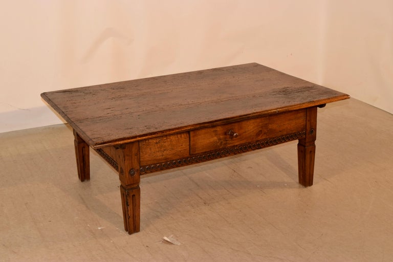 18th century Swiss coffee table made from fruitwood. The top is made from gorgeous planks with wonderful graining and a beveled edge. The apron is simple and has a carved banded edge and contains a single drawer in the front. The table is supported