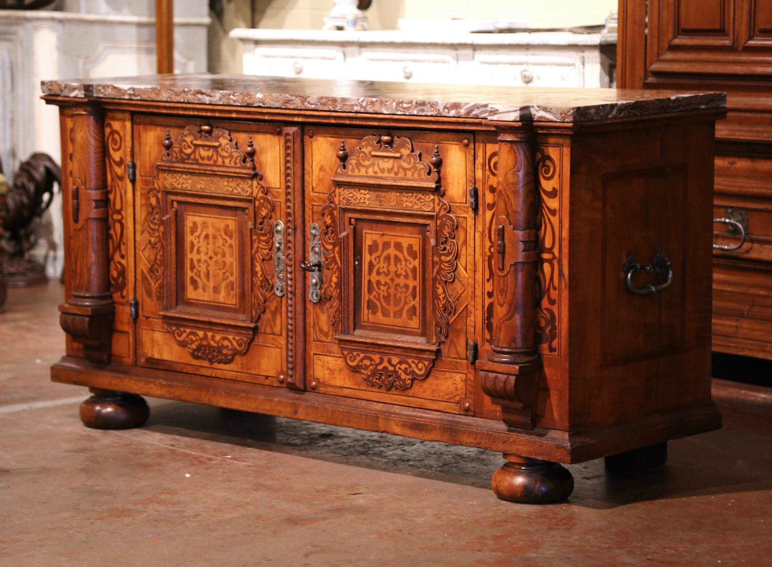 Decorate a dining room or an office with this heavily carved enfilade. Crafted in Switzerland circa 1780, the cabinet stands on bun feet over two intricate doors opening to inside shelving. Both doors flanked with thick side columns in high relief,