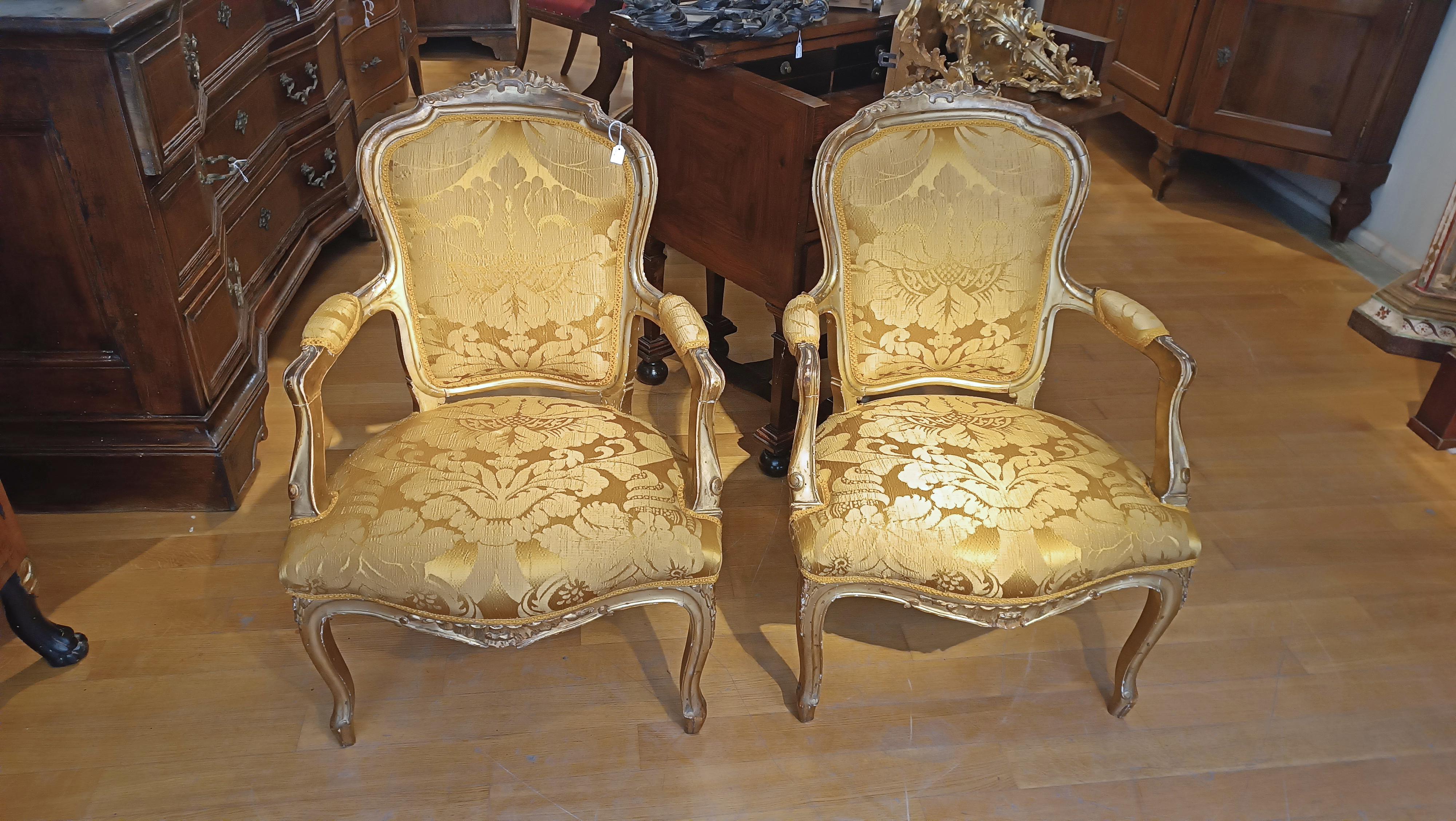 These armchairs in carved pine wood and gilded with gold leaf represent a fine example of Tuscan craftsmanship in eighteenth-century style. The armchairs are characterized by a wavy style that gives them elegance and refinement. The carving