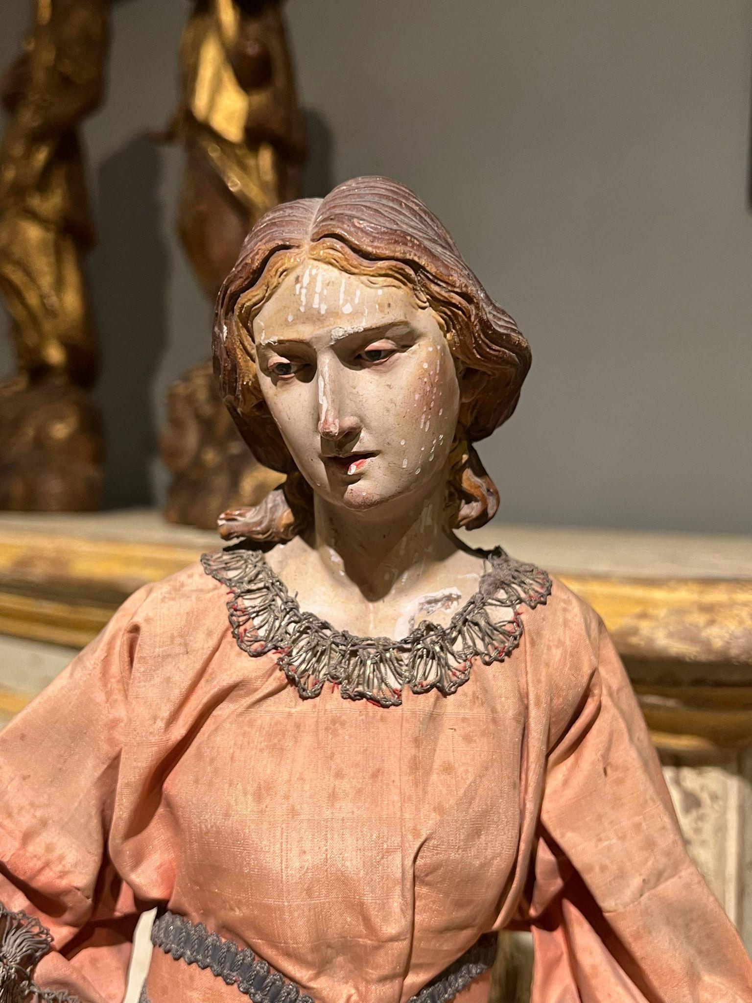 Statue en terre cuite représentant un personnage féminin. La statue est dotée d'yeux de verre et d'une robe d'origine. La qualité du visage et des mains est très raffinée, Naples, XVIIIe siècle.

Dimensions : 11x11x51