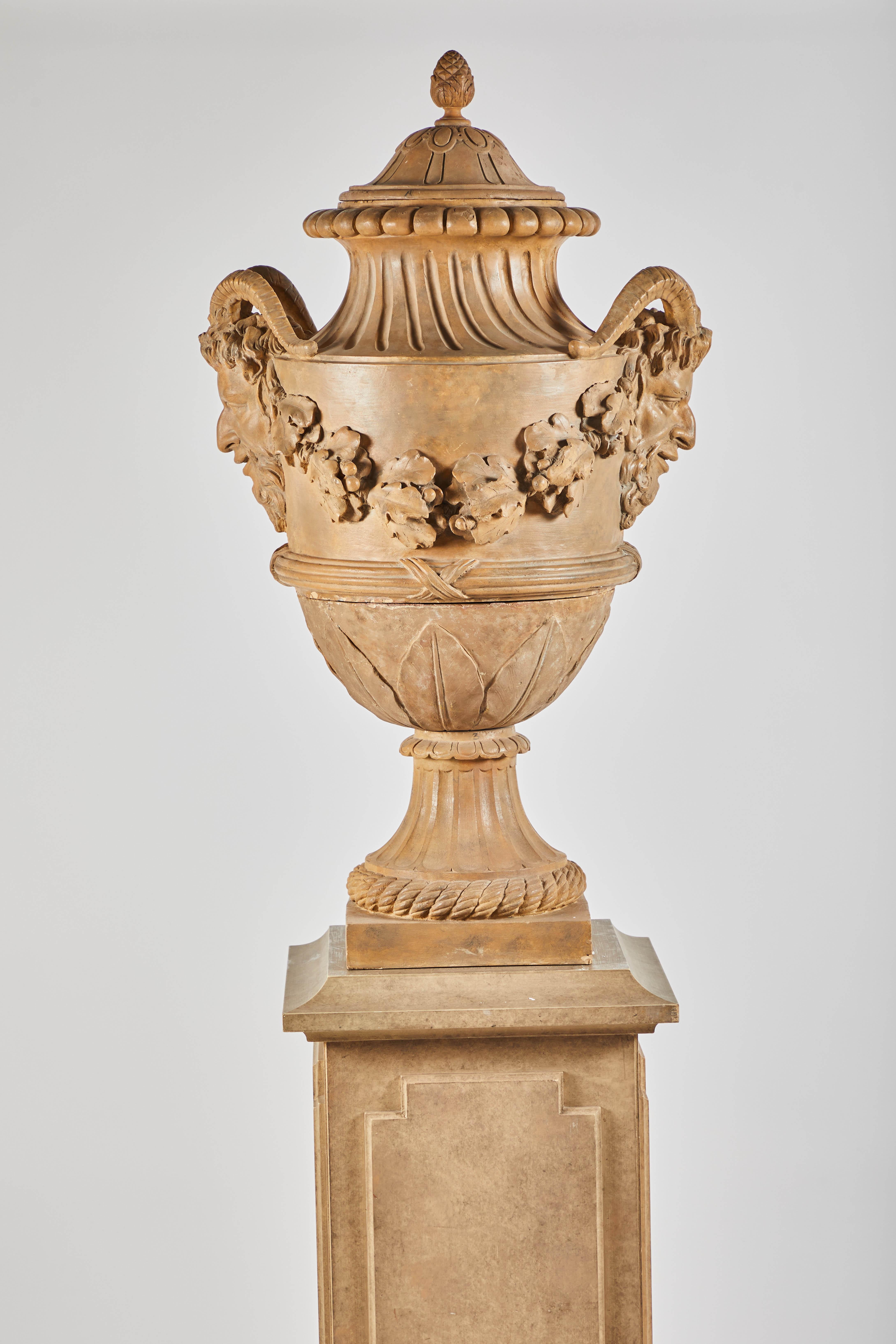 18th century terracotta covered urns on wood pedestals from the collection of Karl Lagerfeld. Extremely well-cast garlands swag between handles in the form of Satyrs.

Measures: 101.5