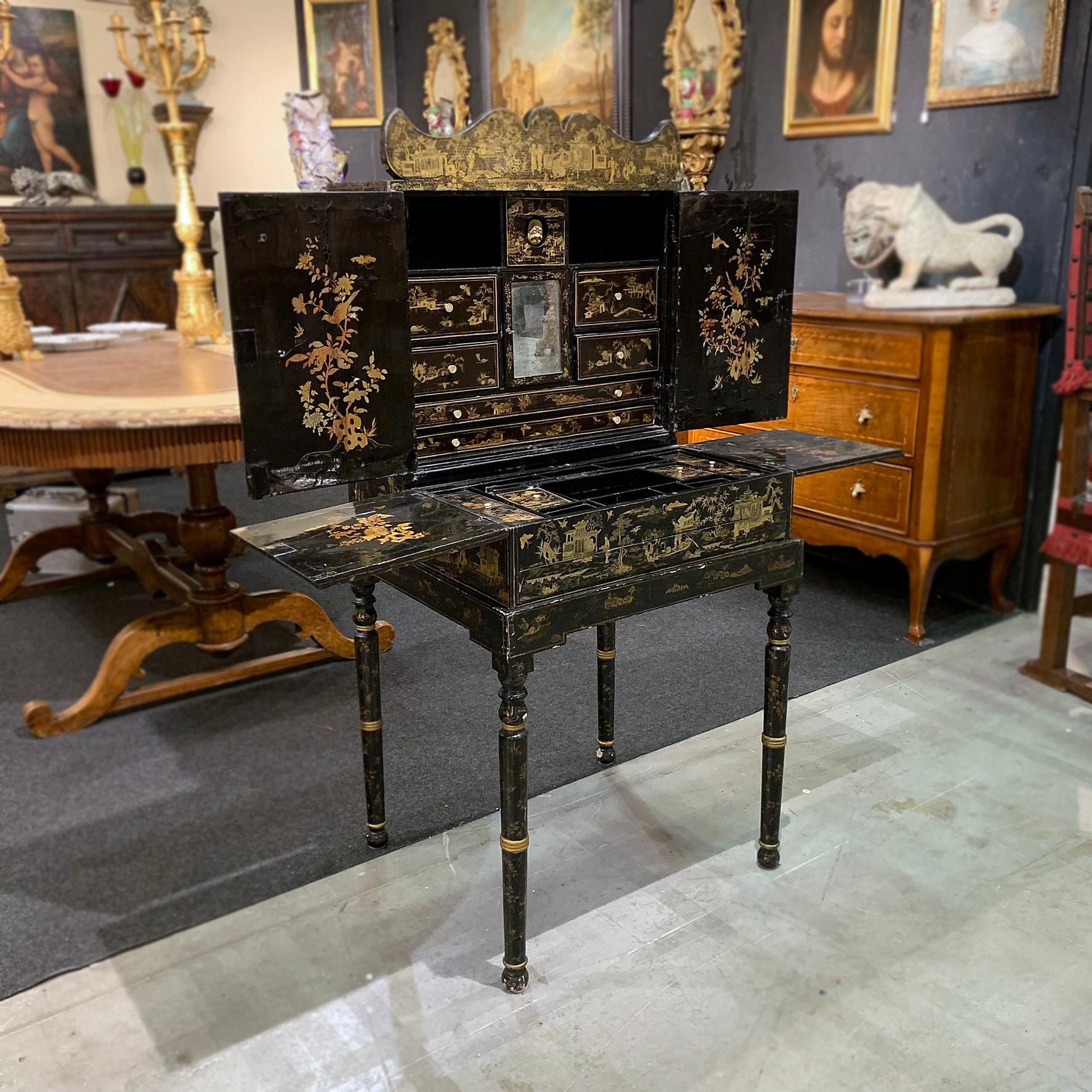 Stunning travel cabinet in ebonized wood, made in China, dating back to around the 19th century during the Qing dynasty. Made with precious materials such as the chalky background and rice paper, it is decorated with scenes painted on a graffitied