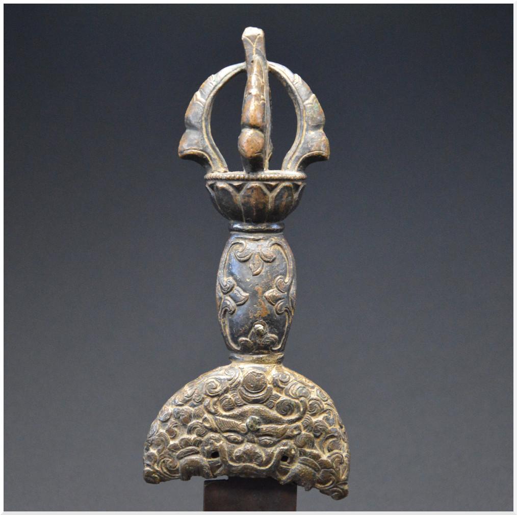 Tibet 18th century
Bronze
Measures: 25.7 x 8.8 cm including stand
Old traces of gilding
French private collection

Old Kartika handle (ceremonial cleaver) in finely chiseled bronze. The handle engraved on both sides, the guard presenting a