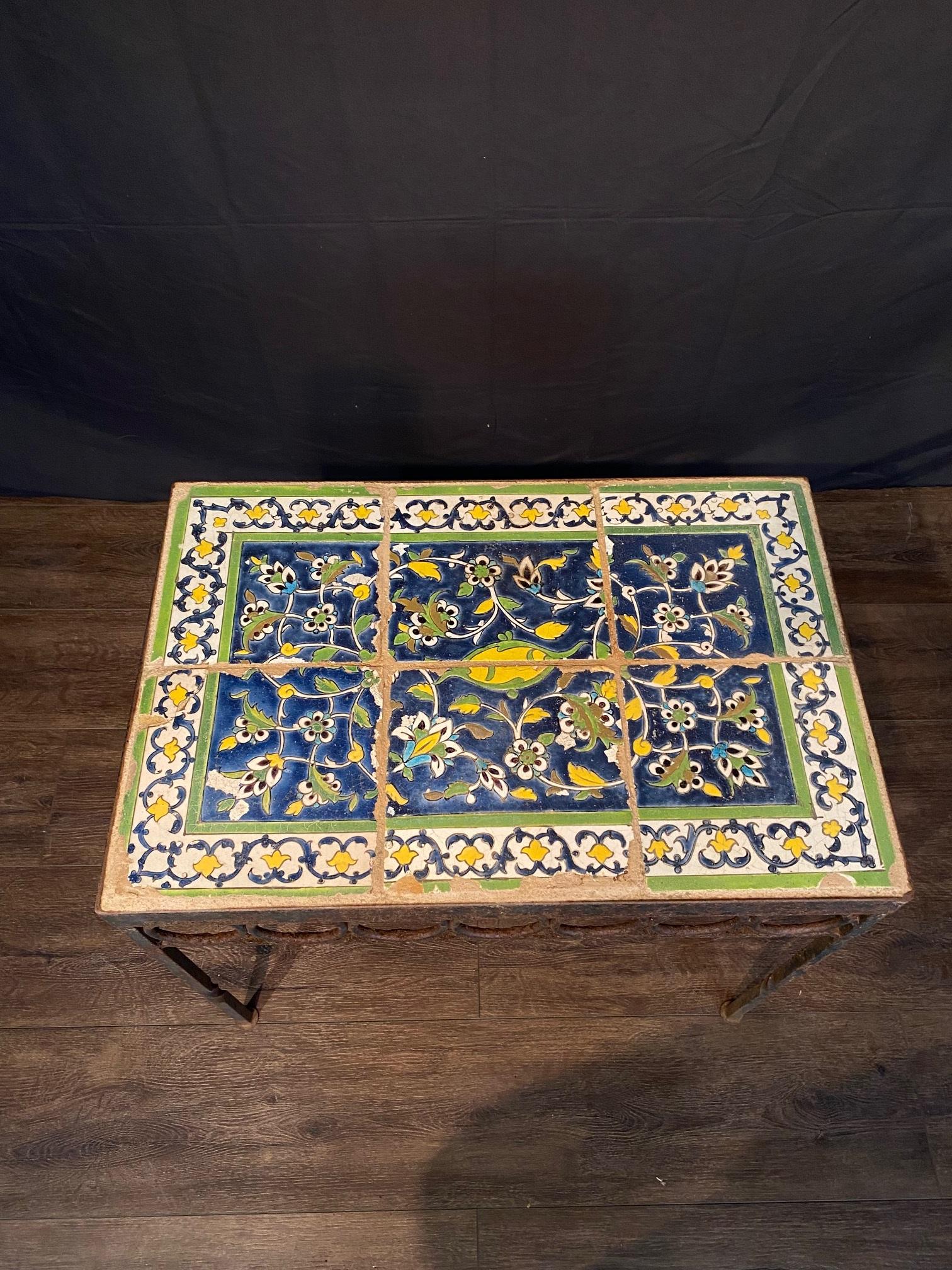 Antique wrought iron table with beautiful 18th century tile top made from 6 large delft tiles. Lovely sculpted wrought iron base, stunning blue green and yellow colors, very nice antique item with great style and form. Lovely in garden or home and