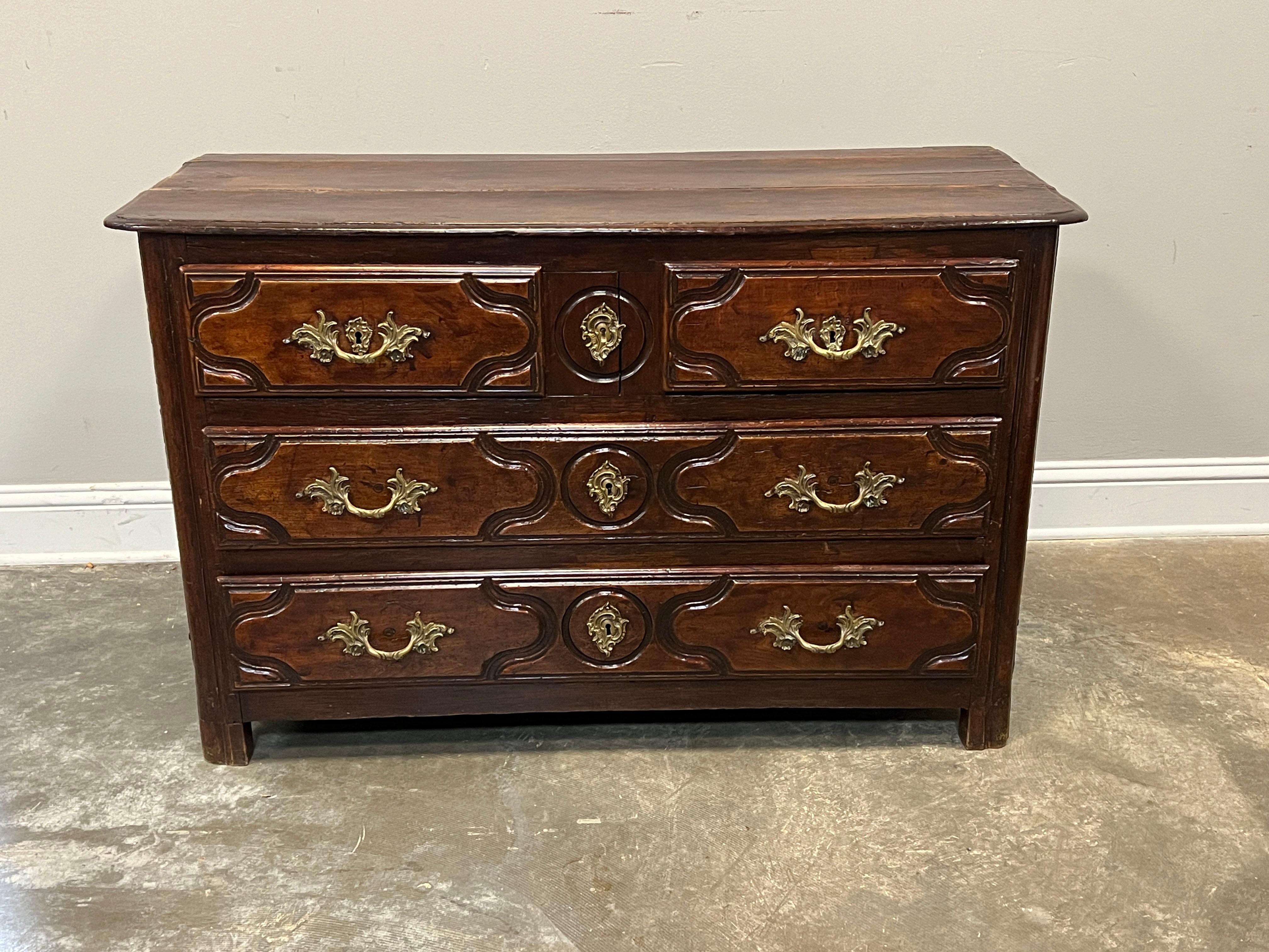 Classic Provincial Louis XV to Louis XVI transitional commode in walnut with original hardware. Straight traverse, two drawers over two long drawers. The commode is hand constructed with dowels on mortise and tenons and drawers have dovetailed