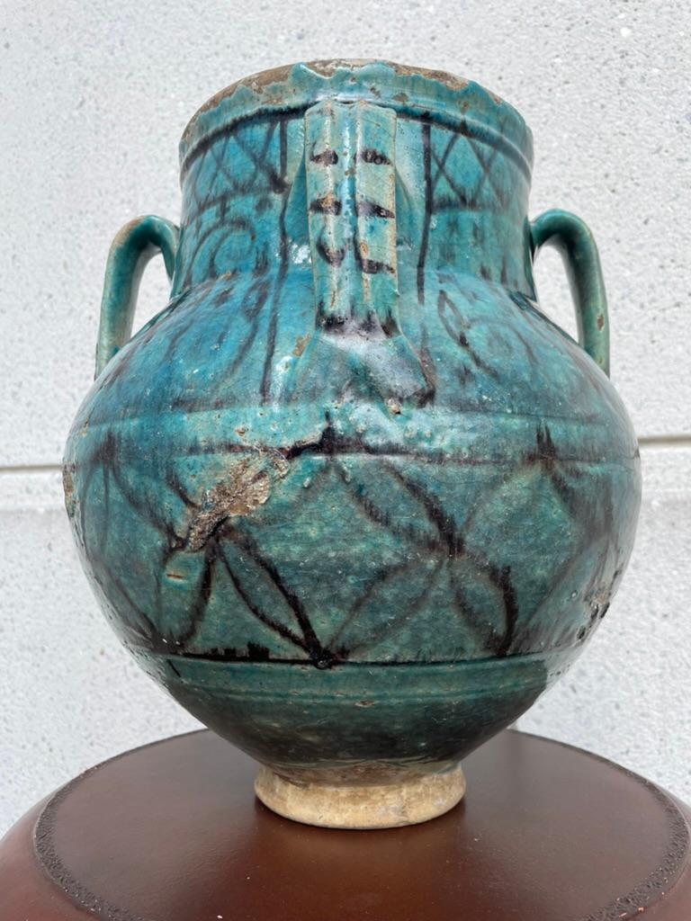 18th century Turkish Ottoman Empire turquoise glazed storage jar with black flora decoration and four looped handles. The wind neck surrounded by four loop handles above a bulbous body supported by an integral base. 
This is a really handsome large