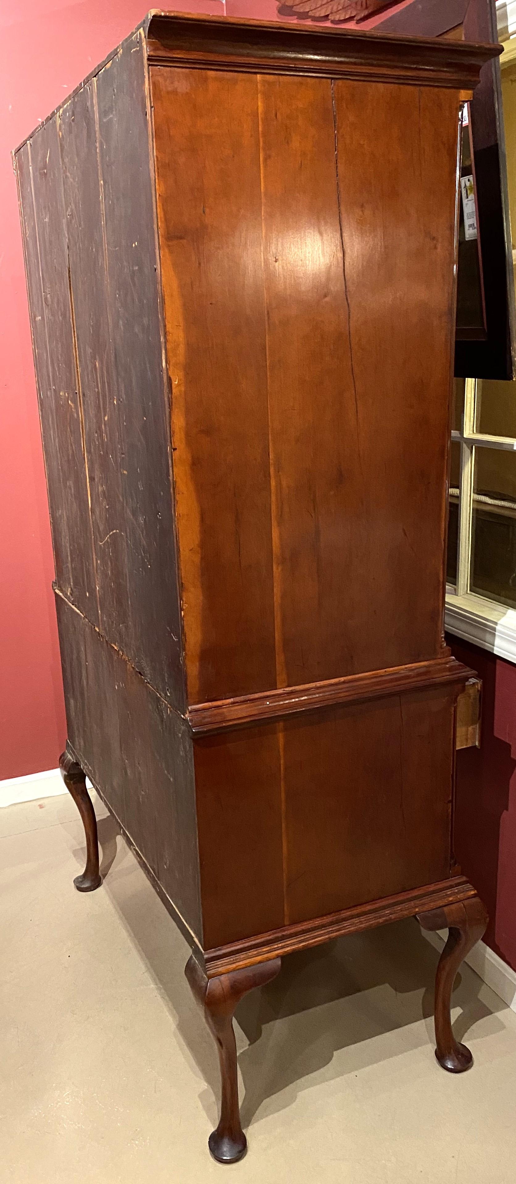 A fine two part Chippendale cherry highboy with a wonderful warm color and patina. The upper case with a molded cornice surmounting three small fitted top drawers over four graduated long drawers, each with period oval brasses, flanked by reeded