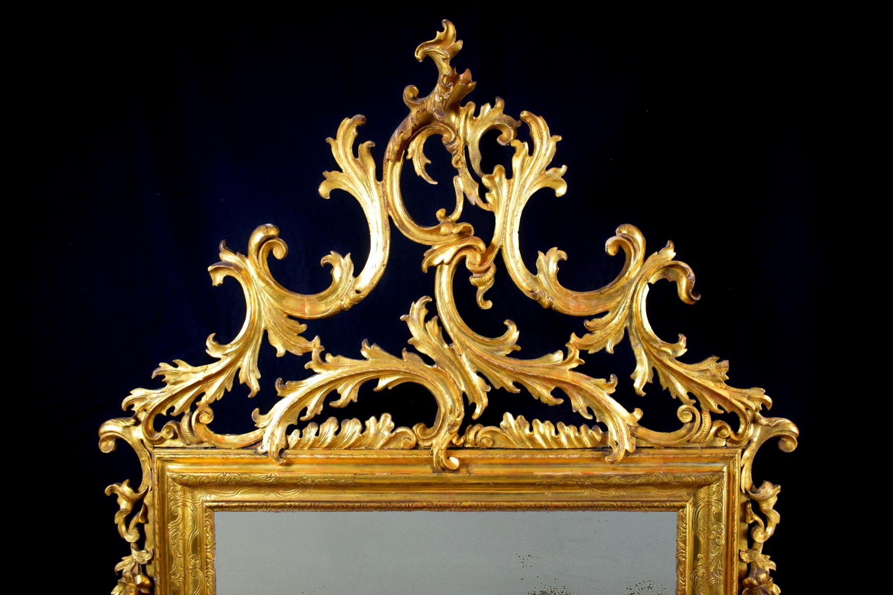 Venezianischer geschnitzter und vergoldeter Spiegel aus dem 18.

Der große, fein geschnitzte und vergoldete Spiegel wurde in der ersten Hälfte des 18. Jahrhunderts in Italien, in Venedig, hergestellt.
Es hat einen zentralen rechteckigen Rahmen