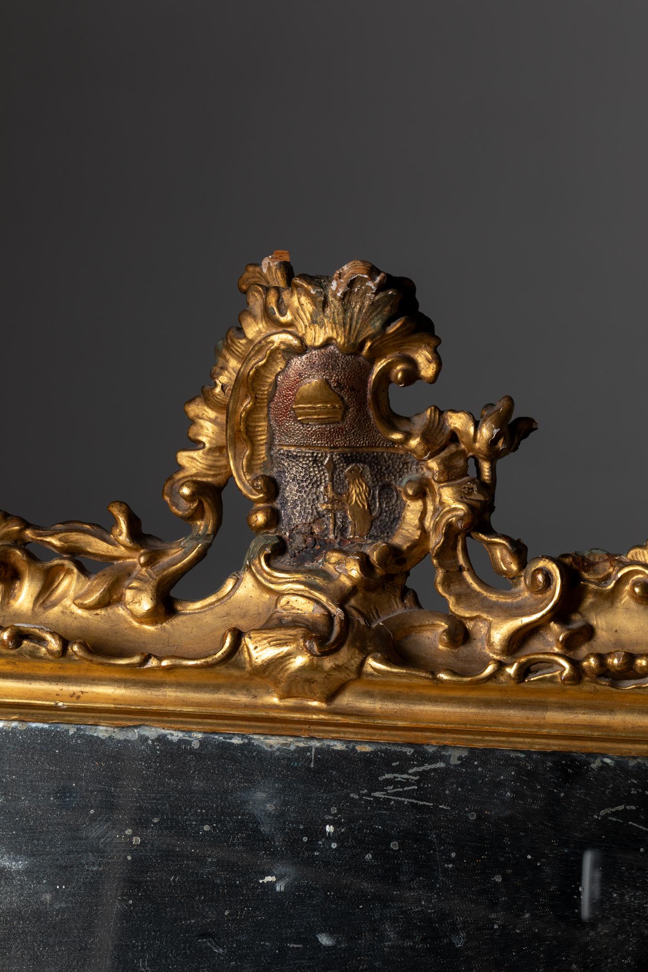 Venezianischer Spiegel des 18. Jahrhunderts aus geschnitztem und vergoldetem Holz mit einem Wappen an der Oberseite (Handgefertigt) im Angebot