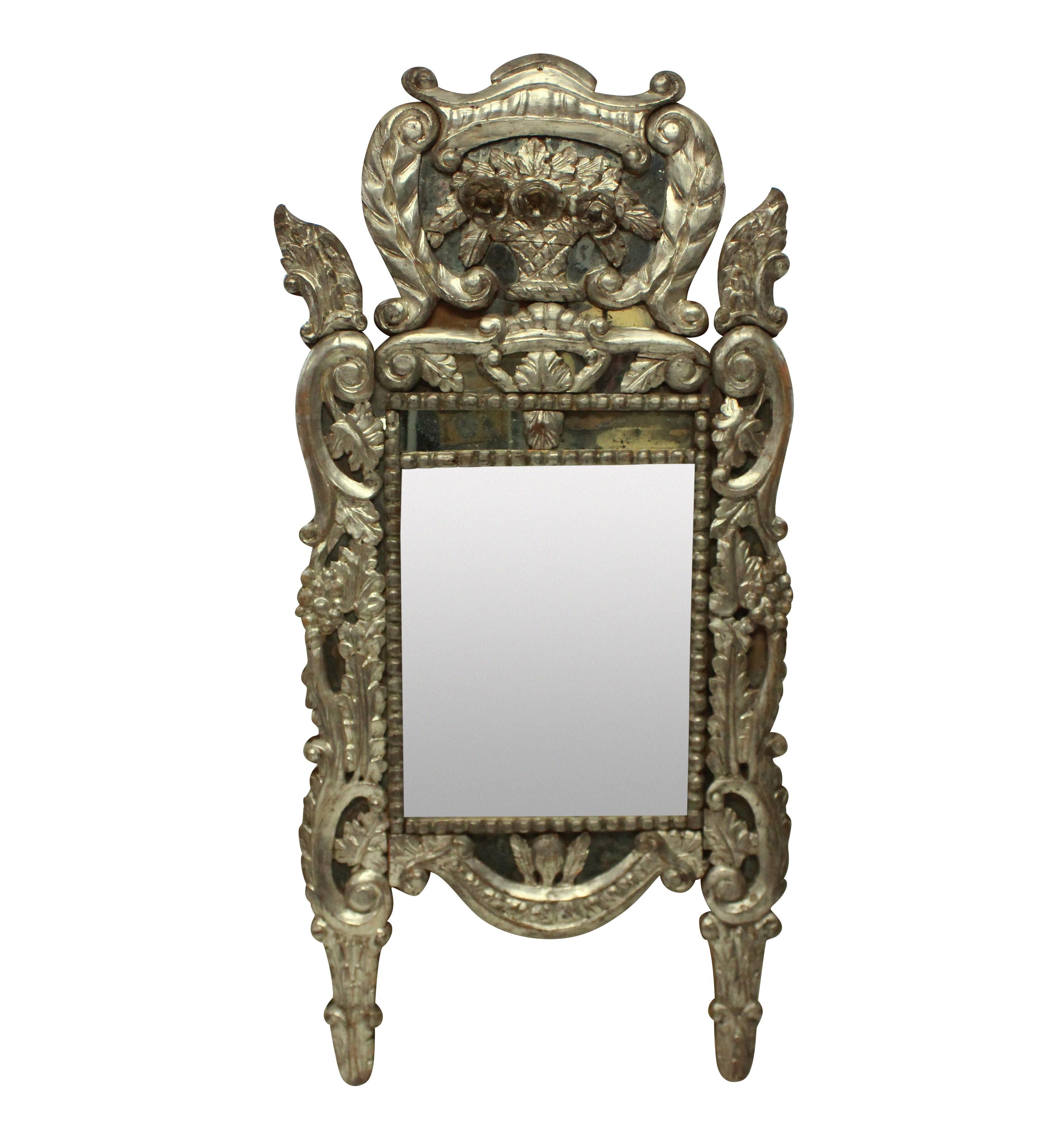 An 18th century carved Venetian mirror in silver leaf, with the original mercury glass. Some minor losses.