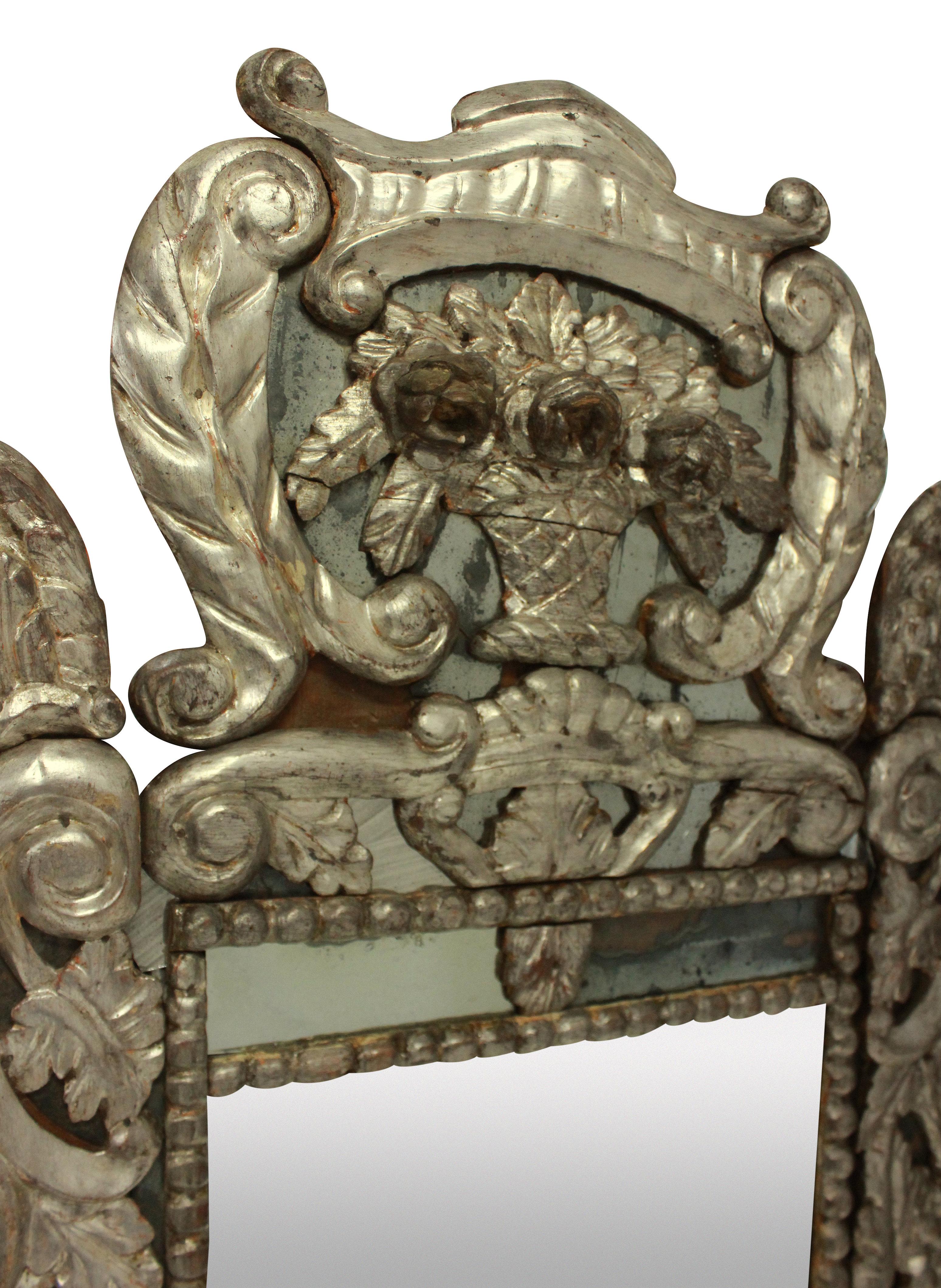 An 18th century carved Venetian mirror in silver leaf, with the original mercury glass. Some minor losses.