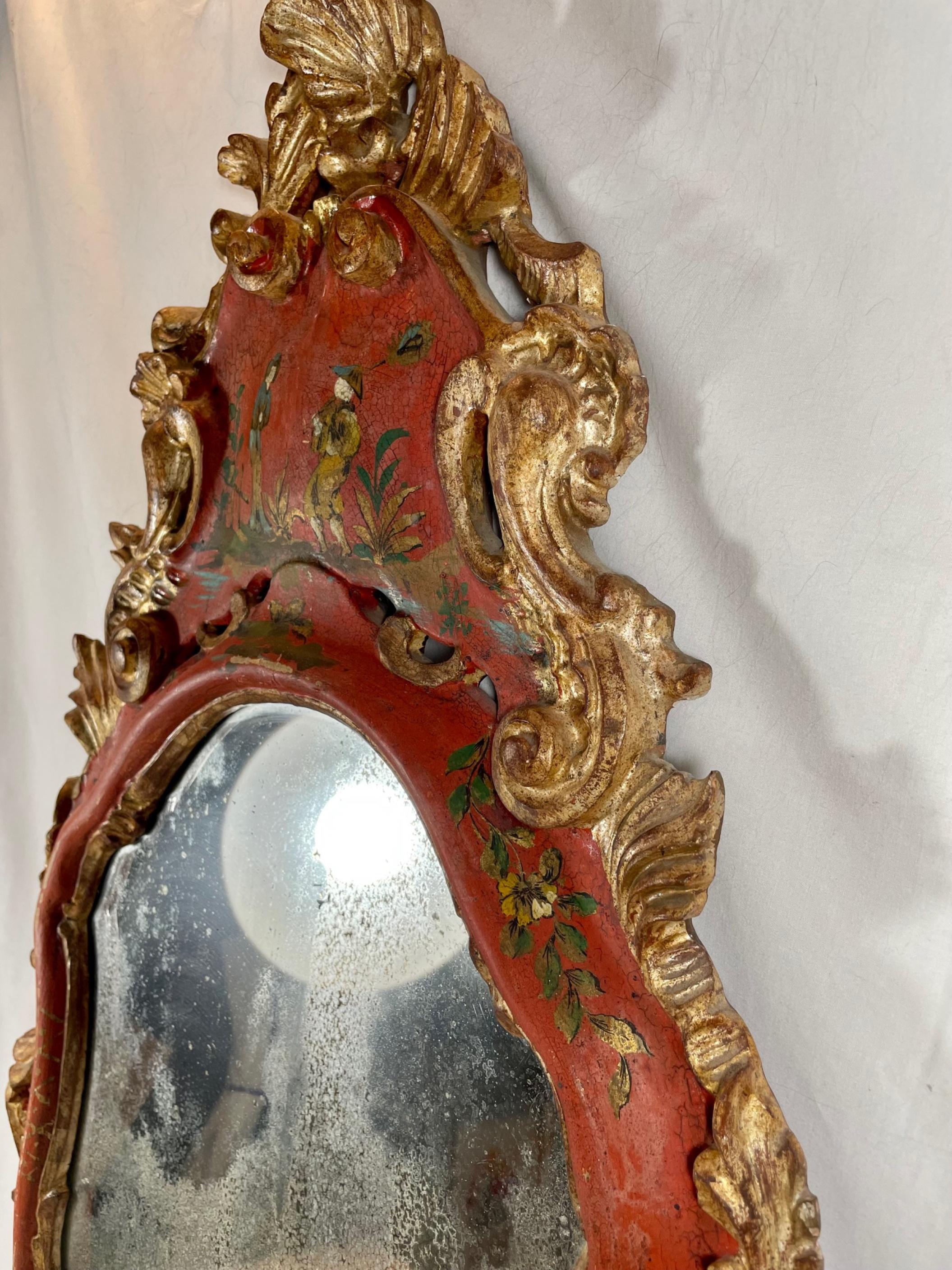 18th century Venetian Rococo polychrome and gilt decorated mirror.

The arched original mirror plate within a red lacquered scrolled and arched frame is decorated at the crest with a courting Chinese couple. Gilded ribbons Meander pleasingly