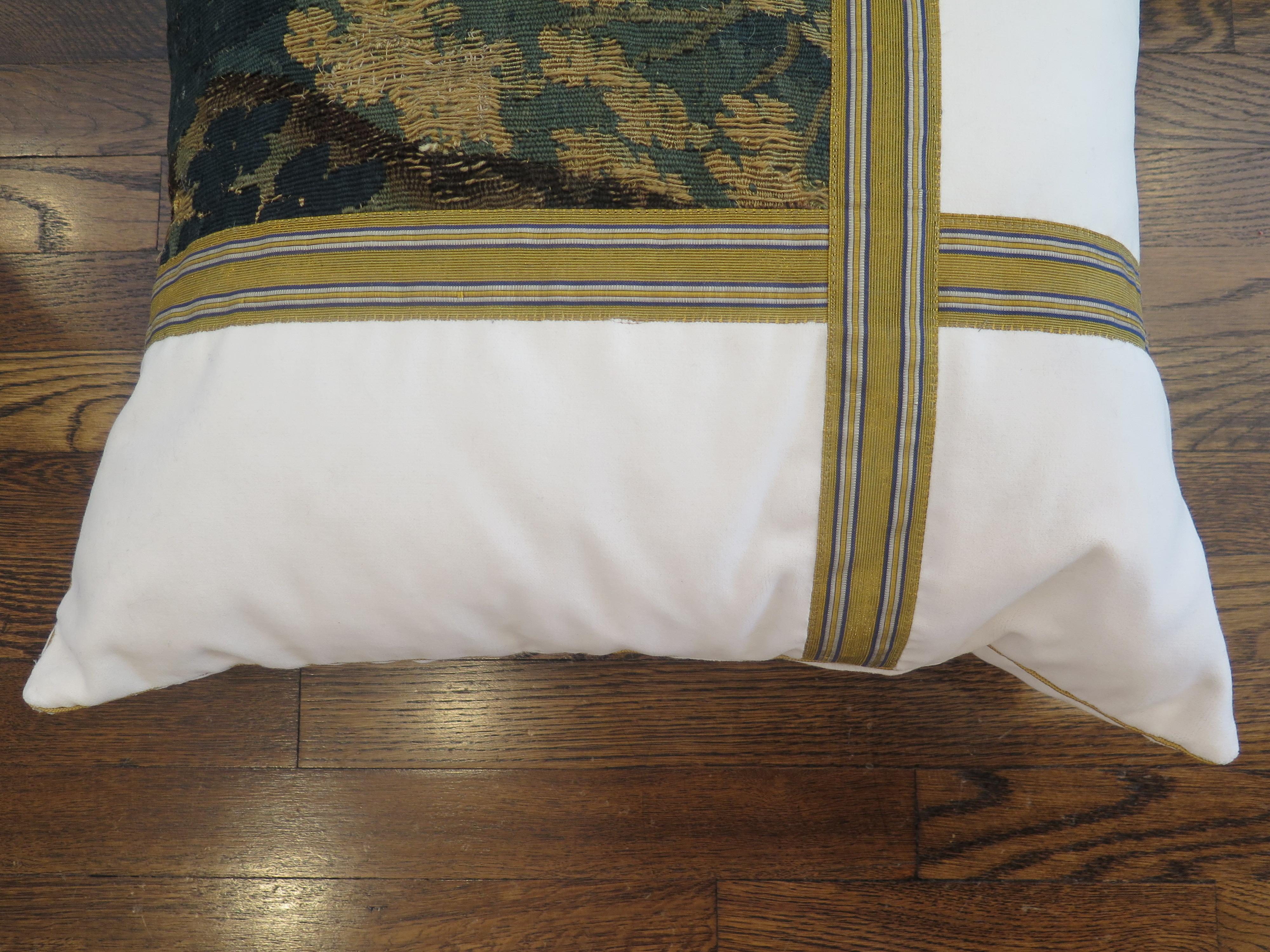Custom 18th century verdure tapestry pillow adorned with antique French gallon. Pillow is constructed out of Holly Hunt Performance white velvet. Down filled.